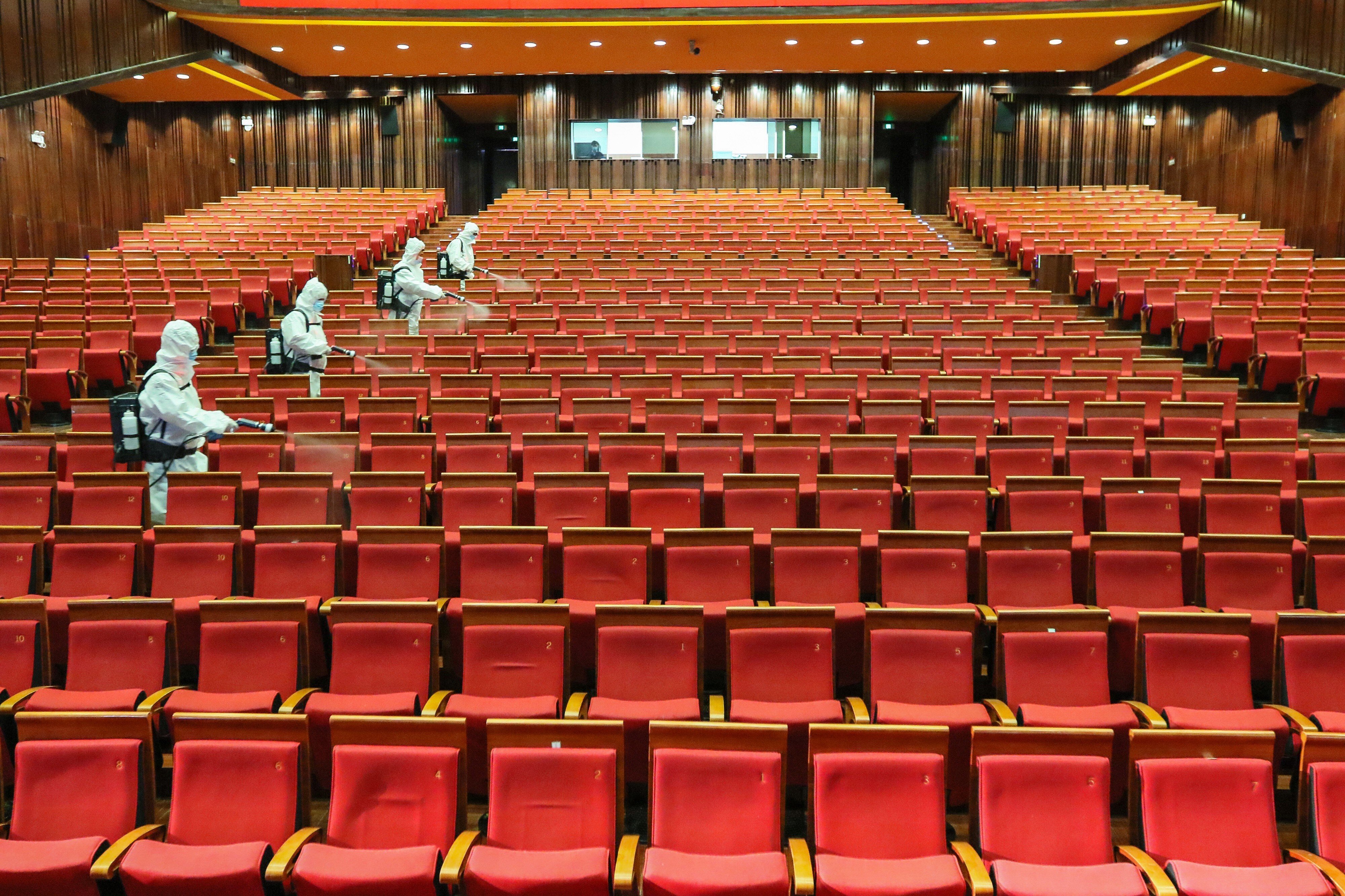 Staff members spray disinfectant at a theatre on May 12 as it prepares to reopen in Yantai, a city in China's eastern Shandong province. Photo: AFP