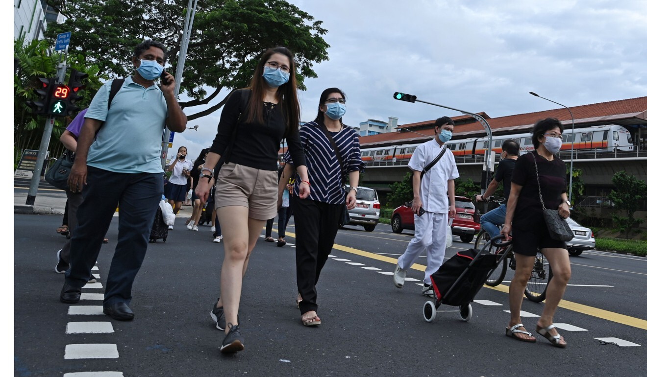 People cross a street in Singapore, as online discussions took place about a citizen charged with spying for China in the US. Photo: AFP