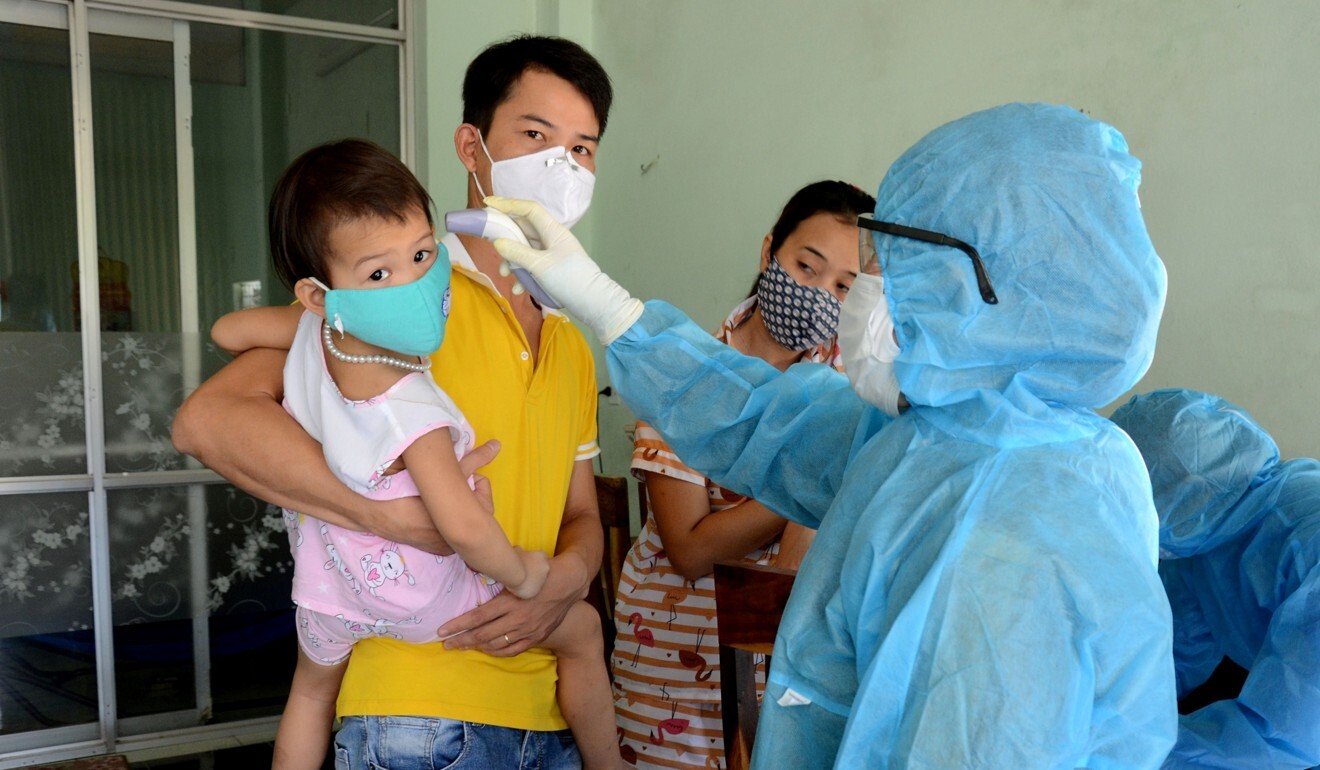 A health worker takes the temperature of residents in Da Nang. Photo: Reuters