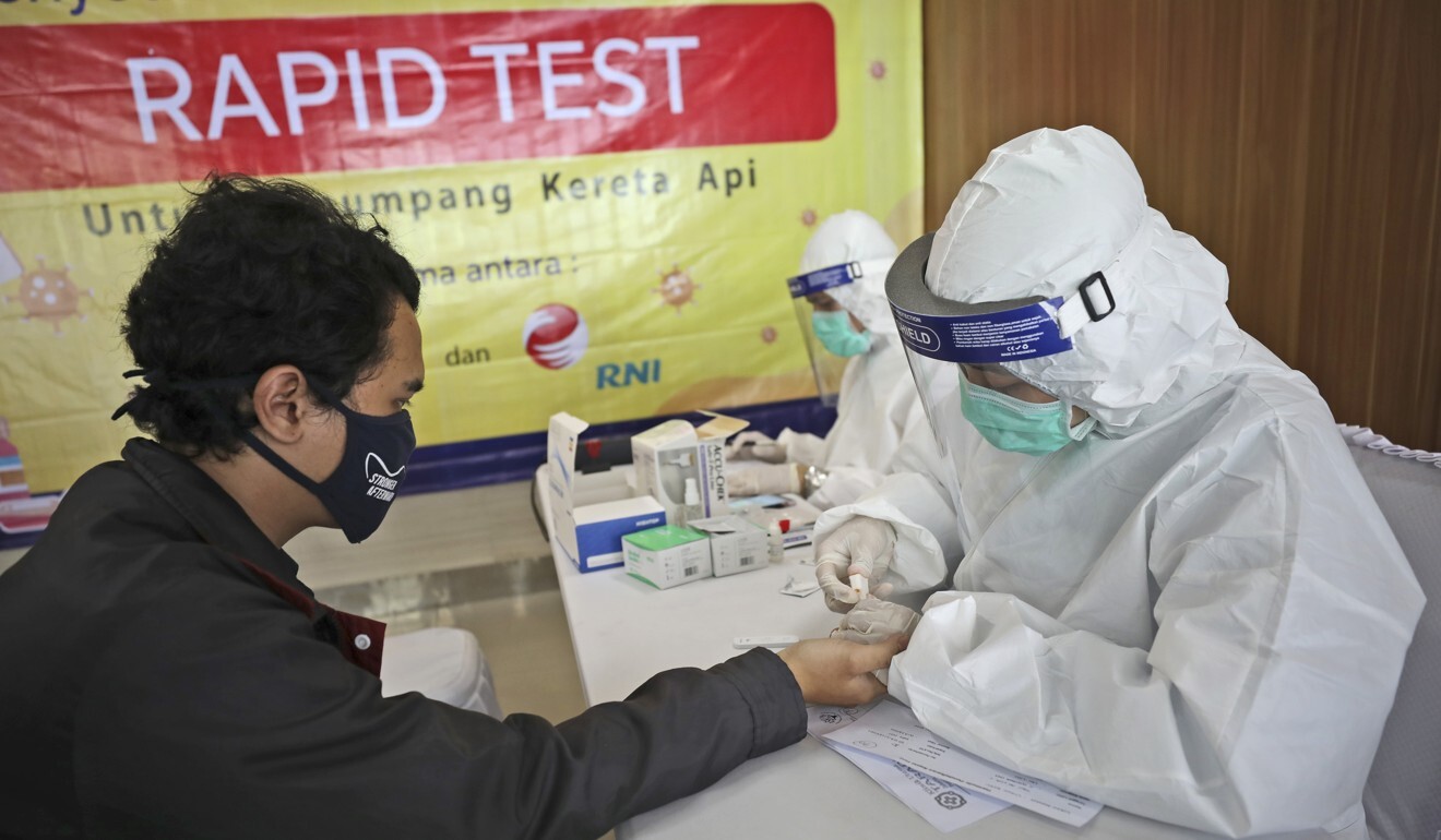 A health worker takes a blood sample from a long-distance train passenger in Jakarta, Indonesia. Photo: AP