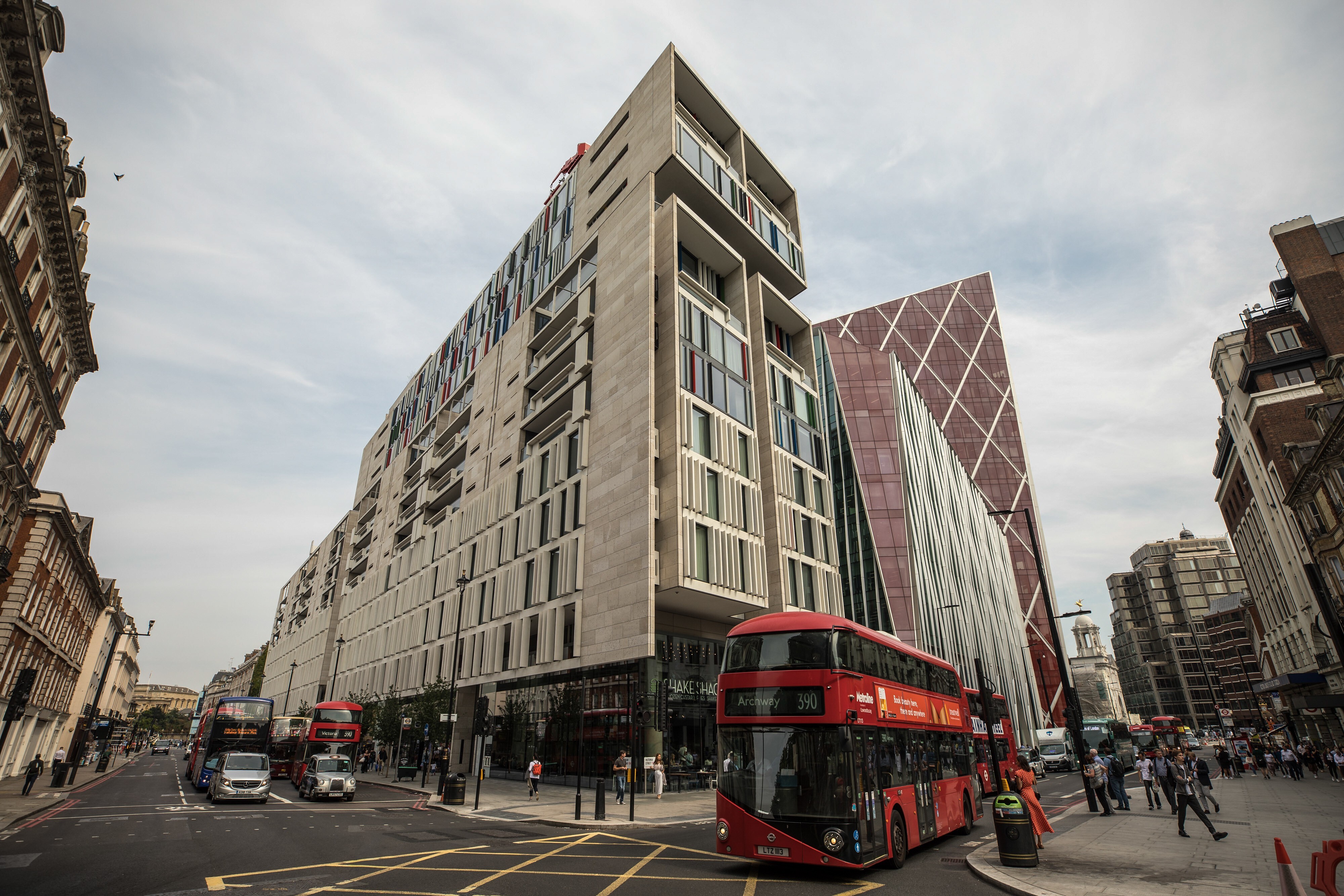 Red London buses pass by a mixed residential and commercial building in the Westminster borough of London that could attract deep-pocketed Hong Kong investors. Photo: Bloomberg