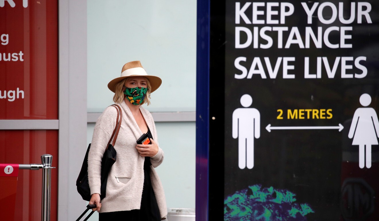 A passenger wearing a protective mask arrives at Birmingham Airport on Monday. Photo: Reuters