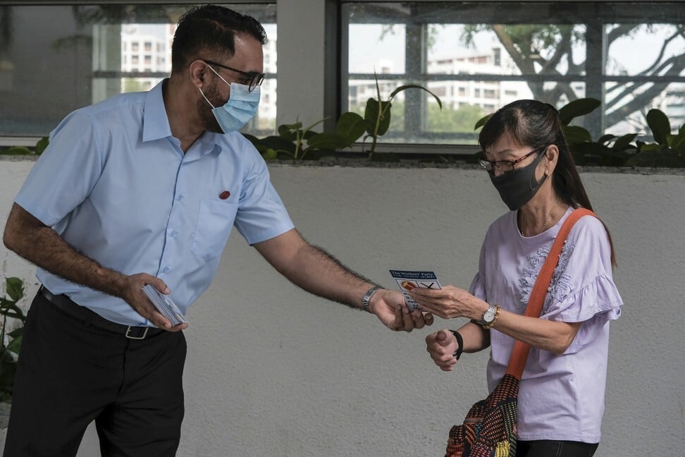 Singh gives a pamphlet to a woman outside the MRT station in Hougang two days before the July 10 election. Photo: AP