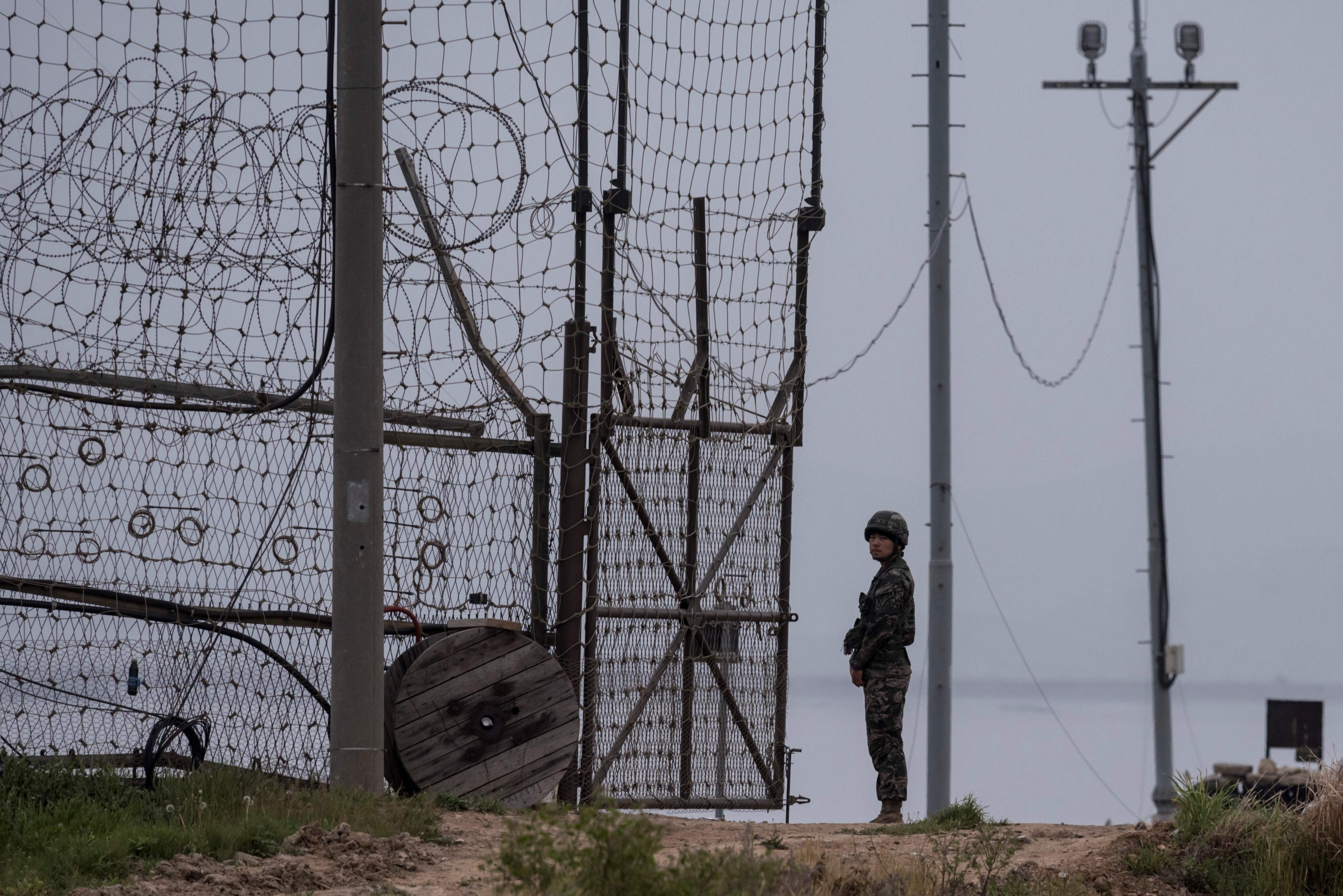 A soldier stands at a fence at the demilitarised zone separating North and South Korea, where a 24-year-old defector is believed to have swum back to the North. Photo: AFP