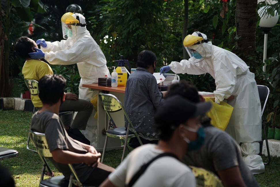 Health care workers collect swab samples from residents at a mobile Covid-19 testing facility in Jakarta on July 29, 2020. Photo: Bloomberg