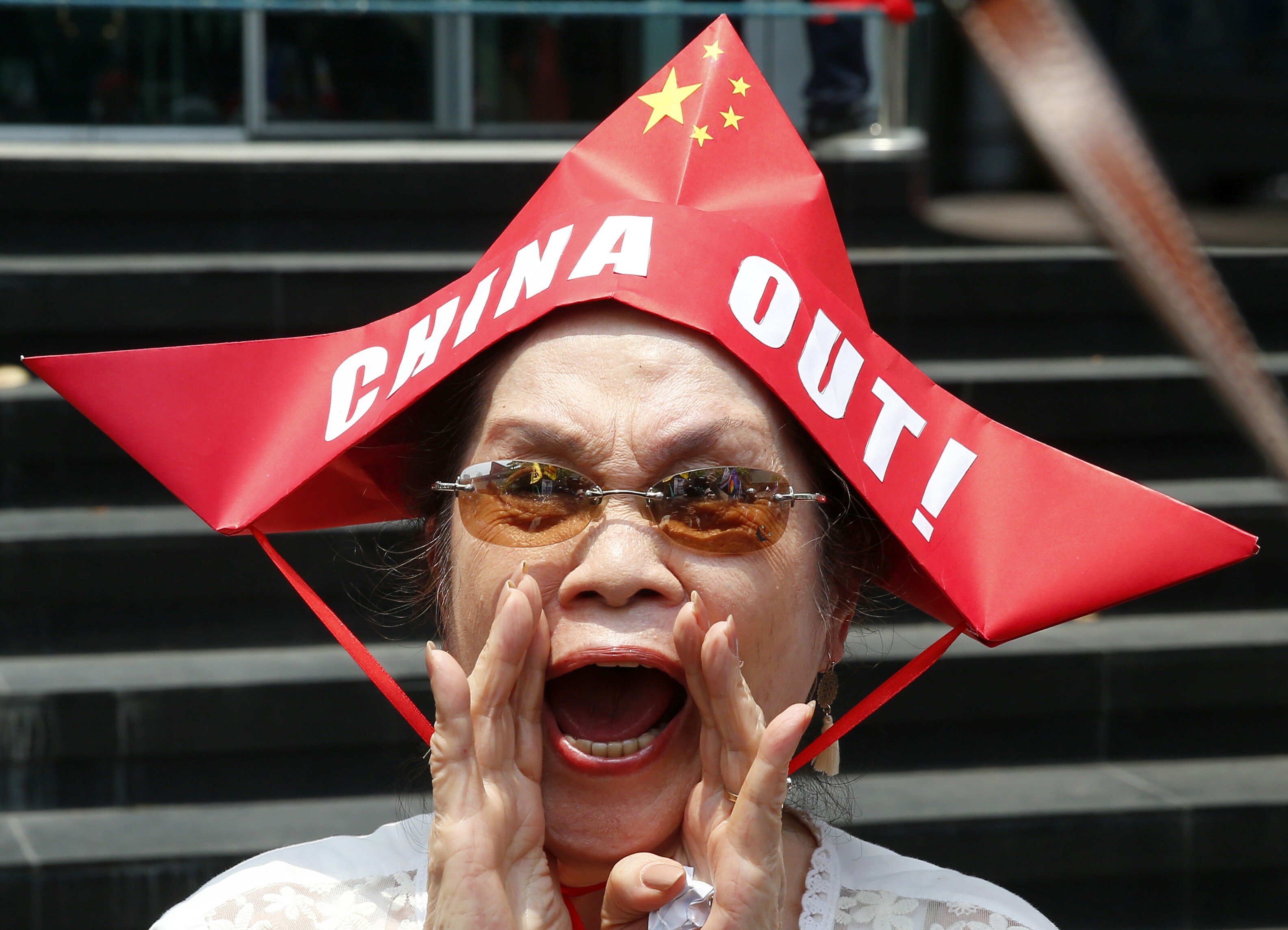 A protester wearing a boat-shaped hat shouts slogans against China’s incursions in the South China Sea. While Philippine diplomats work to strengthen relations with Beijing, there is strong anti-China sentiment among Filipinos. Photo: AP