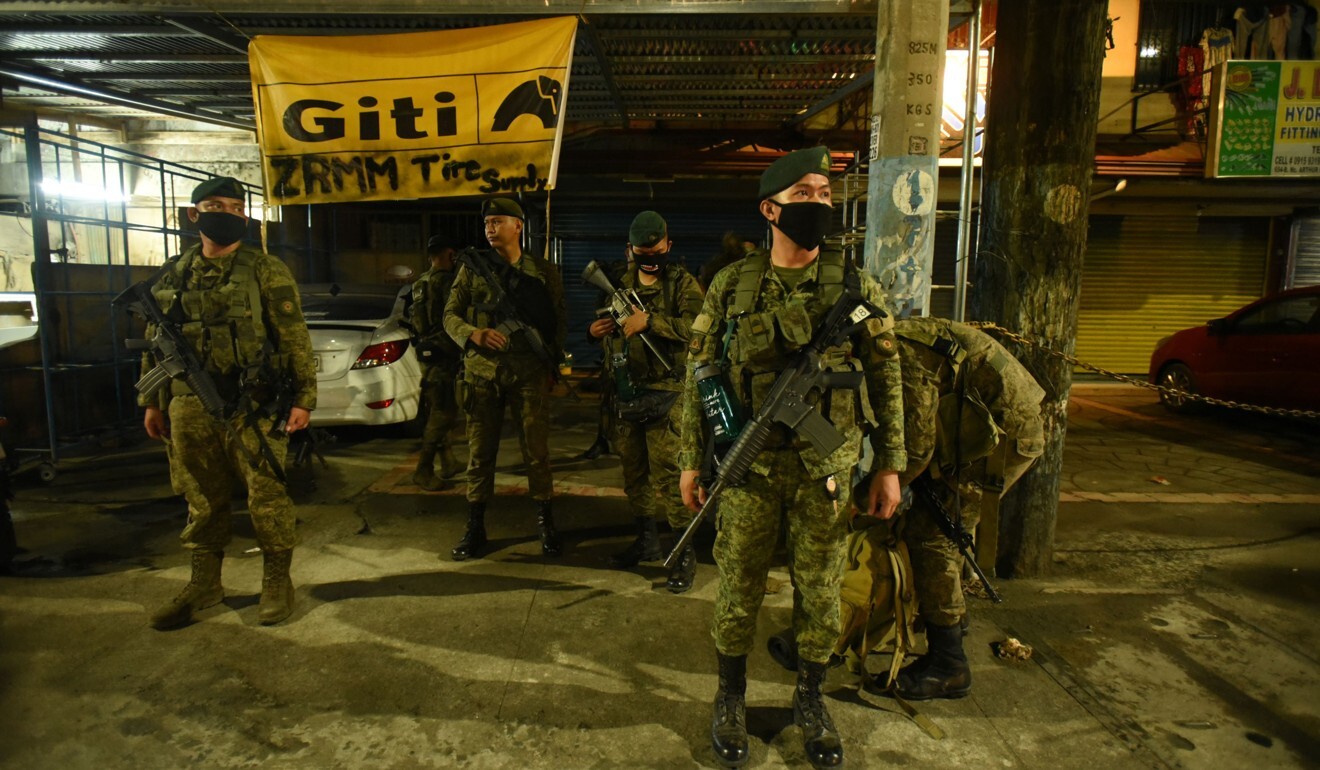 Police and army personnel stand at a checkpoint in Manila amid the capital’s coronavirus lockdown in March. Photo: AFP