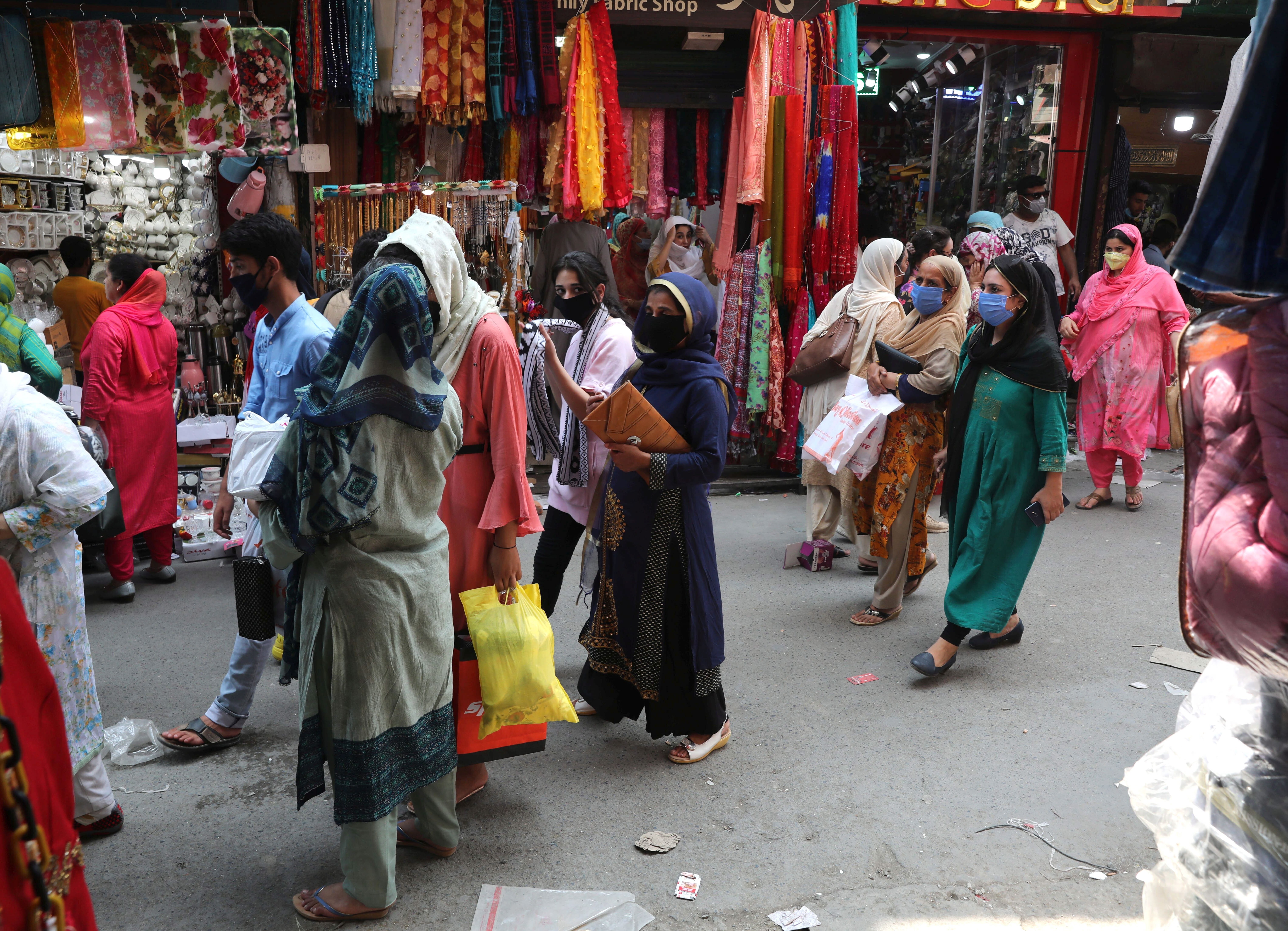 Women are seen shopping in Srinagar, the summer capital of Indian Kashmir, as coronavirus restrictions were eased ahead of the Eid-ul-Adha religious festival. Women have borne the brunt of the ongoing conflict in Kashmir. Photo: EPA