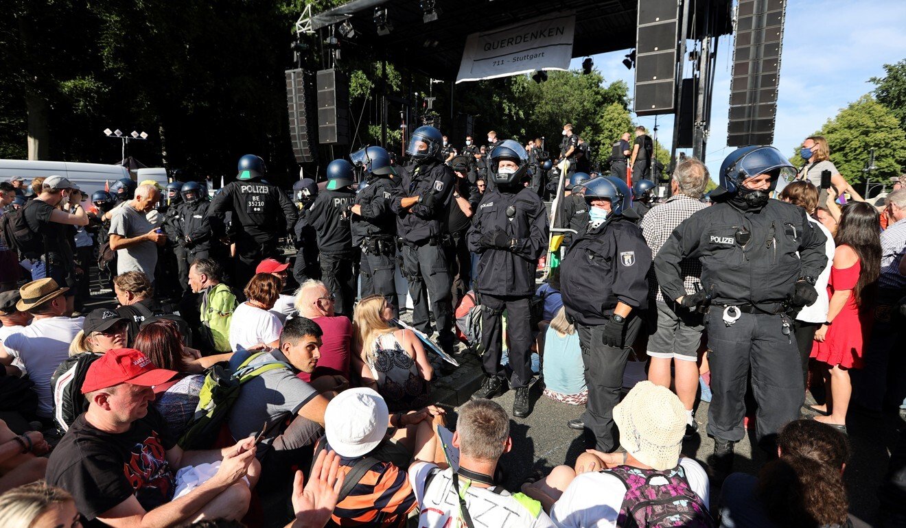Police officers stand next to demonstrators during a protest against the government's coronavirus restrictions. Photo: Reuters