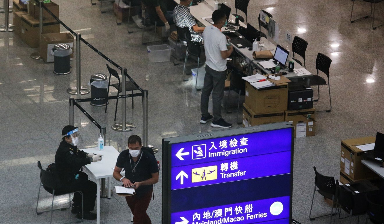 Inbound travellers receive their quarantine wristbands upon arrival at the Hong Kong International Airport in July. Photo: Nora Tam