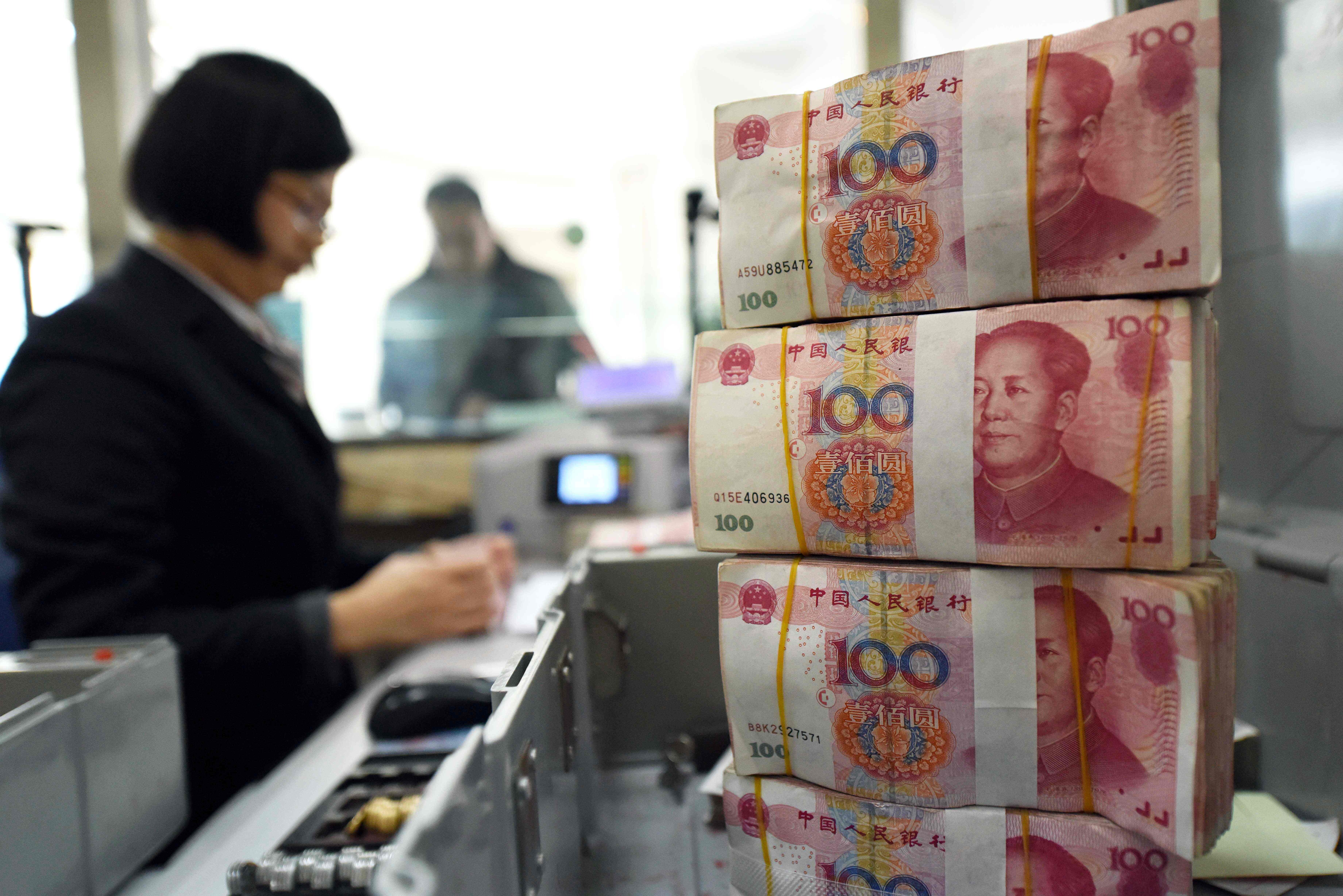 A teller counts money at bank in Lianyungang, Jiangsu province. Photo: AFP