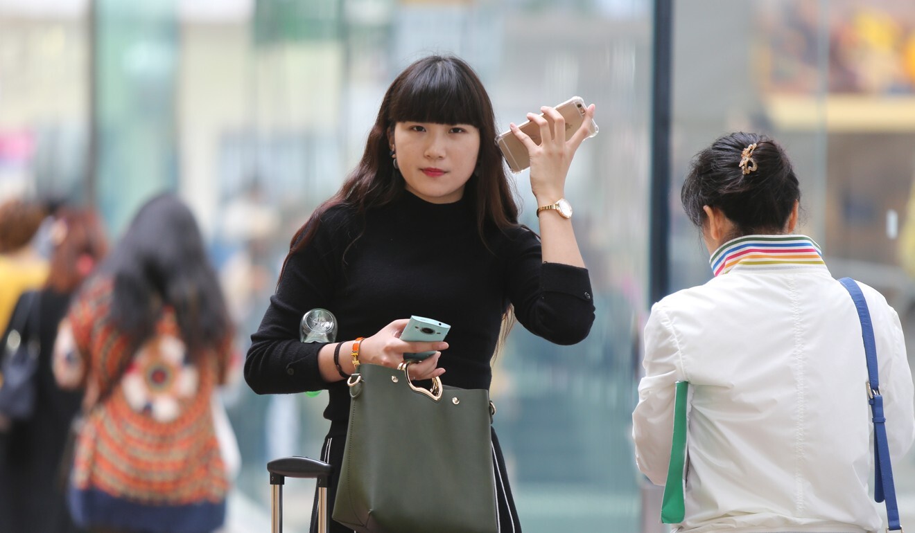 Kobieta odbiera telefon w Causeway Bay w Hongkongu. Zdjęcie: Xiaomei Chen