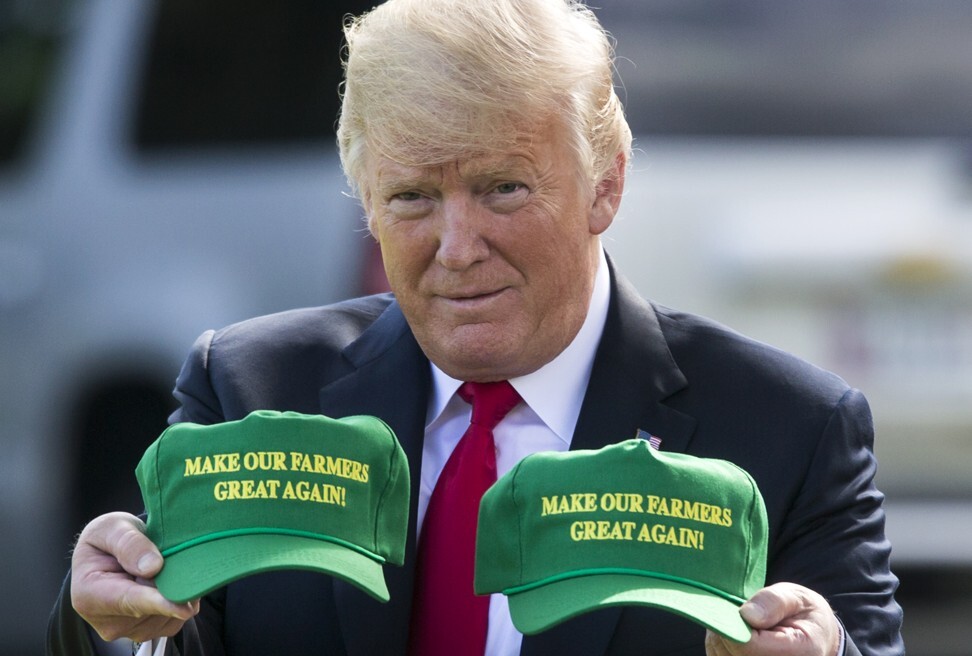 Президент США Дональд Трамп поднимает шляпы со словами: «Сделайте наших фермеров снова великими!» в августе 2018 года. Зеленый и желтый - знаковые цвета компании John Deere, основанной в 1837 году. Фото: EPA