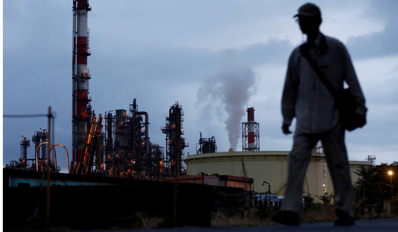 FILE PHOTO: A man walks past a factory at the Keihin industrial zone in Kawasaki, south of Tokyo. Photo: Reuters