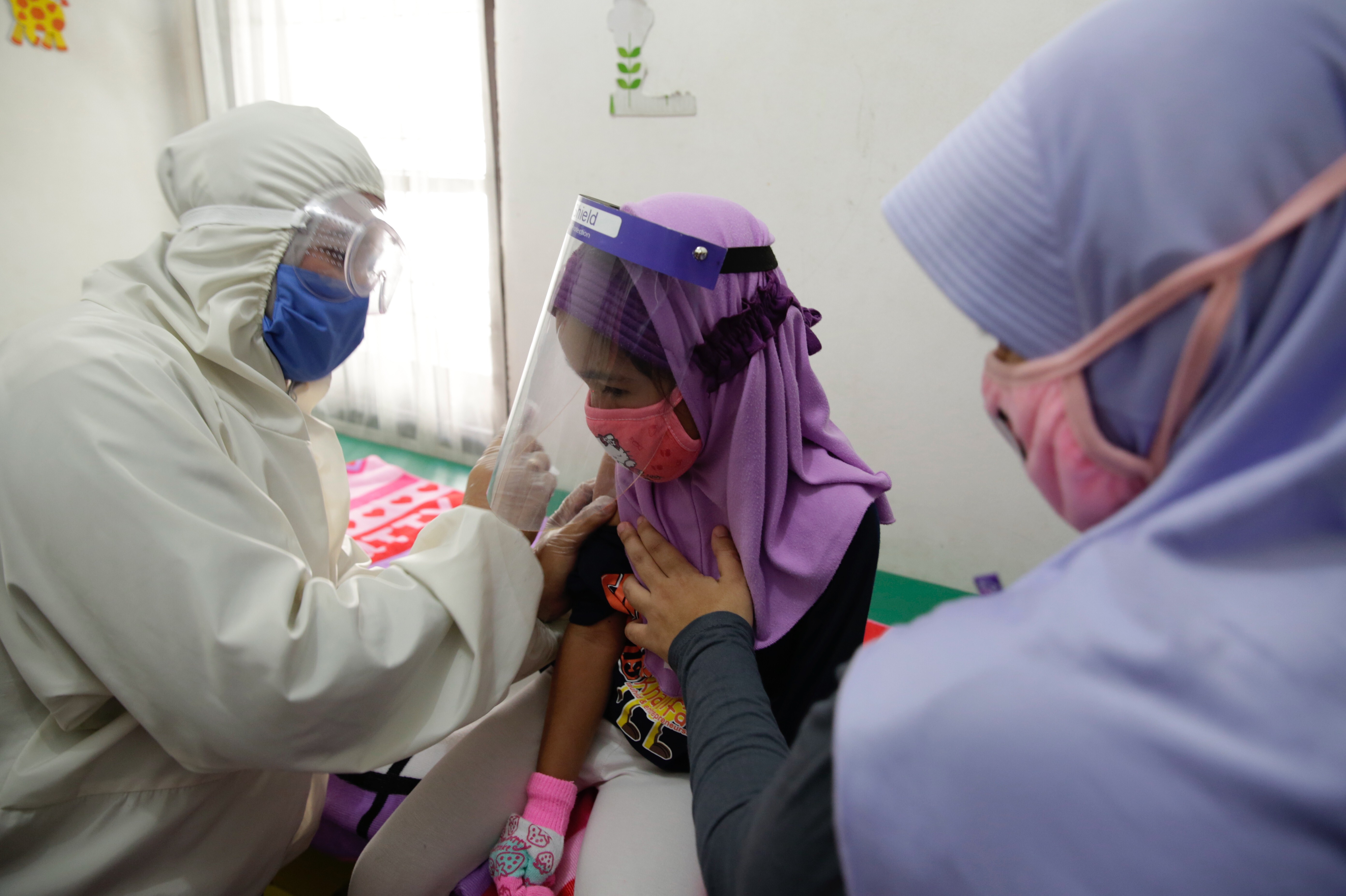 A doctor wearing a hazmat suit pictured administering a vaccine for a patient in Depok, Indonesia. Photo: EPA