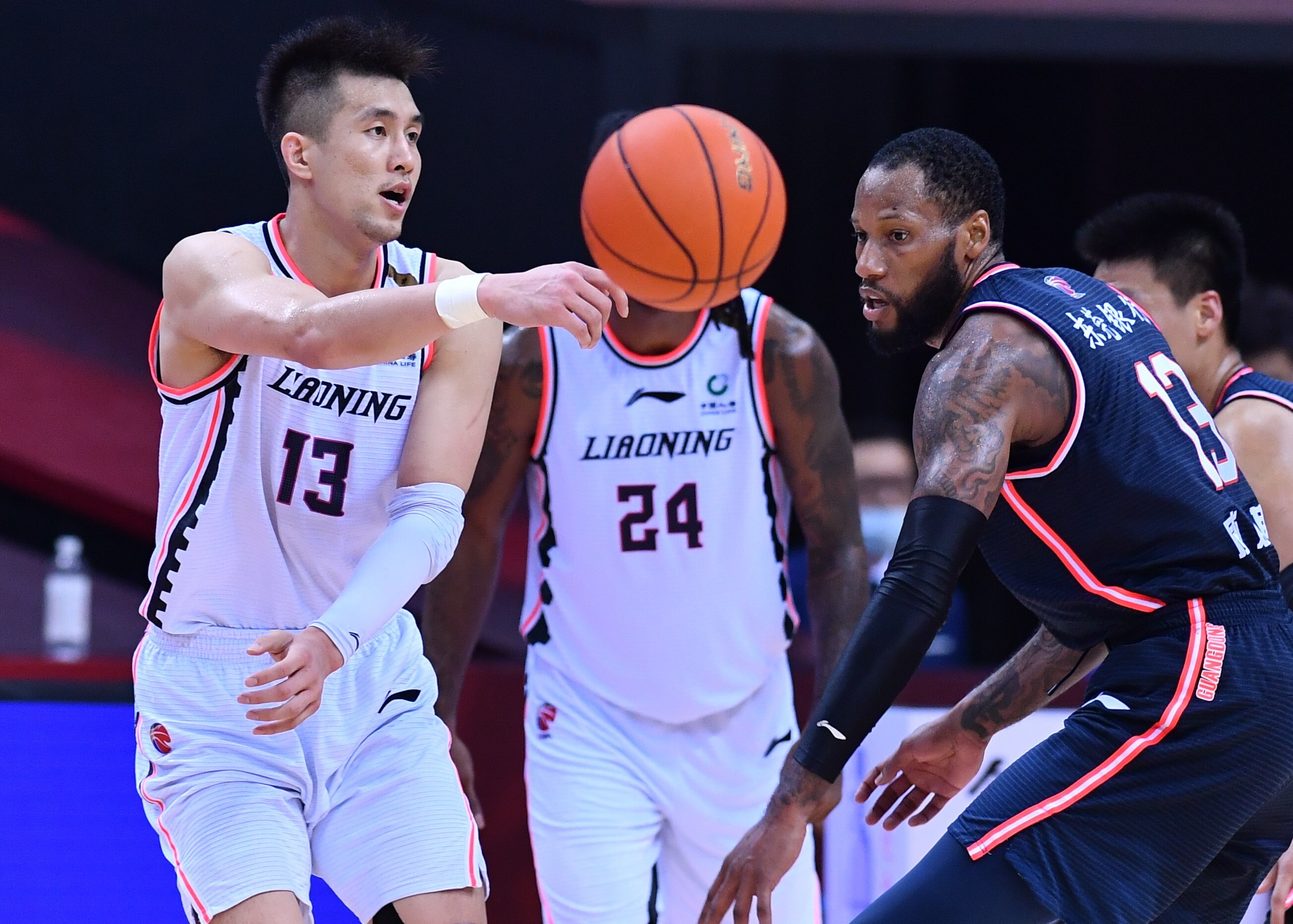 Guo Ailun (left) of Liaoning Flying Leopards passes the ball during the second game of the finals between Guangdong Southern Tigers and Liaoning Flying Leopards. Photo: Xinhua