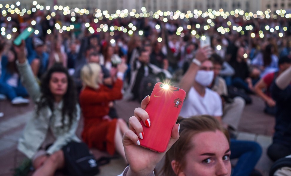 Demonstrators raise their lit mobile phones in Independence Square during a protest in Minsk on Friday. Photo: AFP