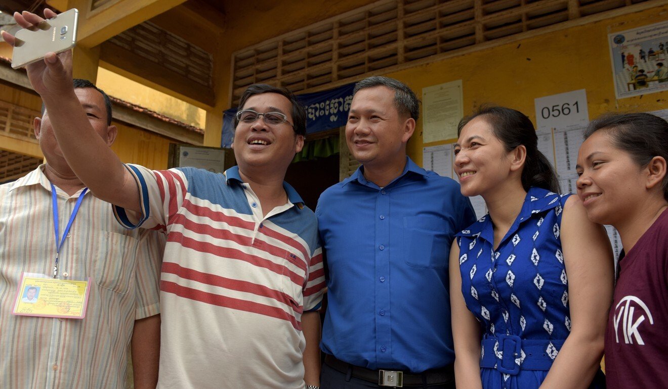 Hun Manet, son of Cambodian Prime Minister Hun Sen, and his wife Pich Chanmoy pose with voters after casting their ballots in the 2018 general election in Phnom Penh. Photo: AFP