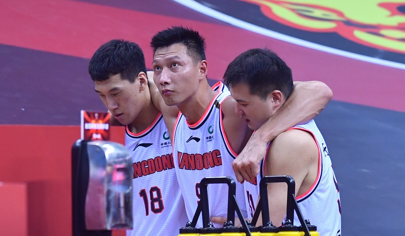 Yi Jianlian (centre) of Guangdong Southern Tigers is helped off the court after injury. Photo: Xinhua