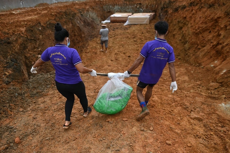 Volunteers carry a bag holding the partial remains of a miner to be buried in a mass grave, one of hundreds who died in the July 2 landslide in Hpakant. Photo: AFP