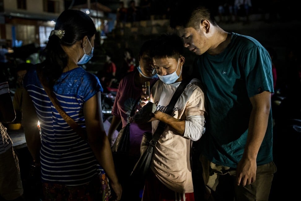 A buyer inspects jade being sold in a market in Hpakant. Photo: Hkun Lat