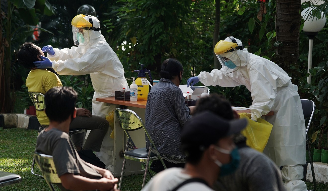 Health care workers at a mobile Covid-19 testing facility in Jakarta, Indonesia. Photo: Bloomberg