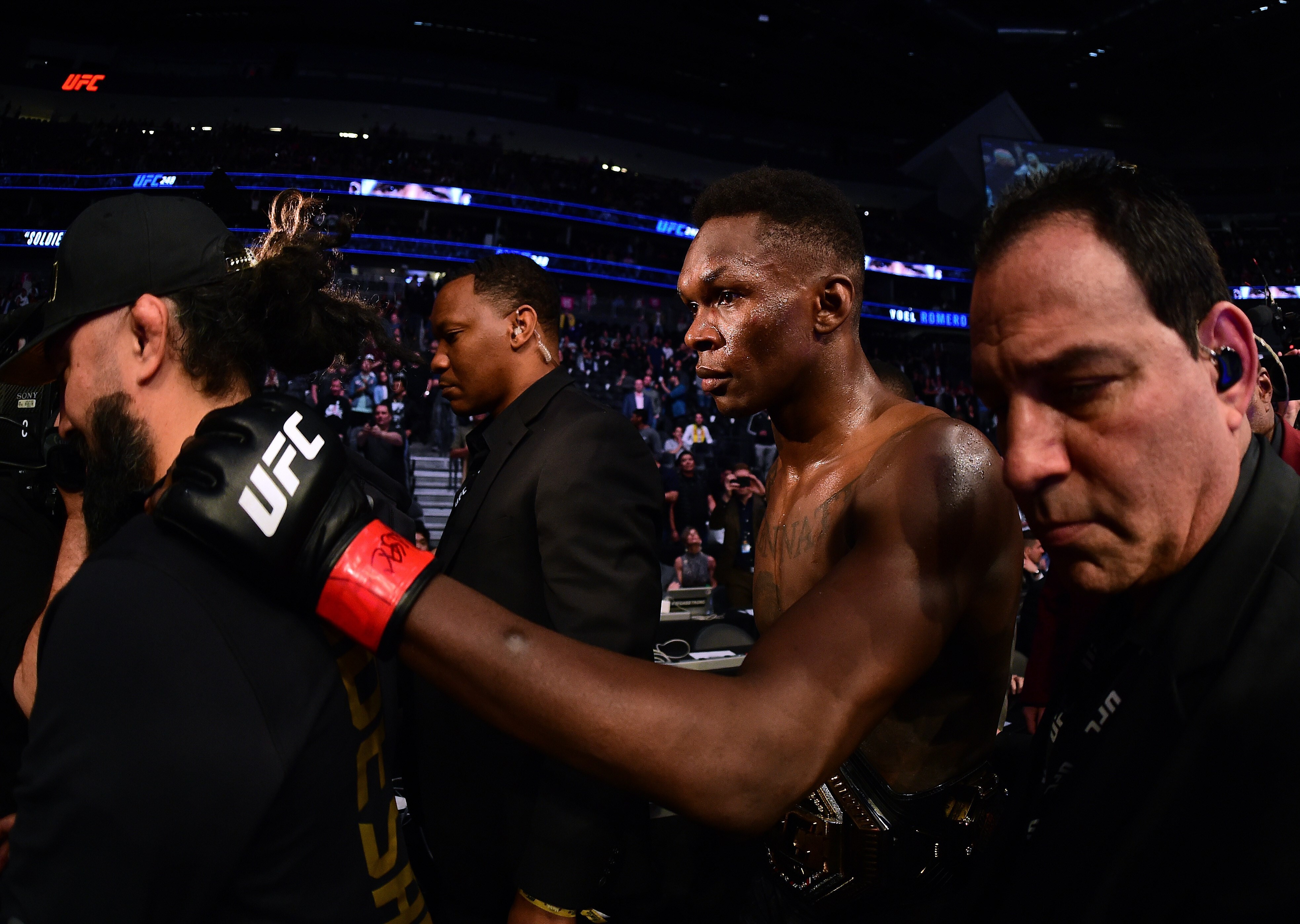 Israel Adesanya is escorted out of the ring after a decision win over Yoel Romero during a middleweight title bout at UFC 248. Photo: AFP