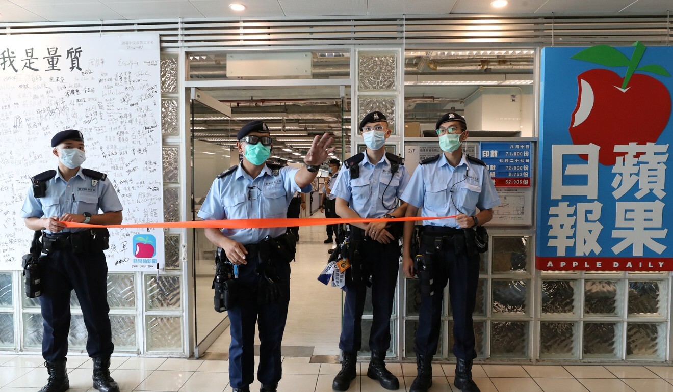 Police officers stand guard in front of the Apple Daily office in Hong Kong as it was raided on August 10. Photo: Reuters