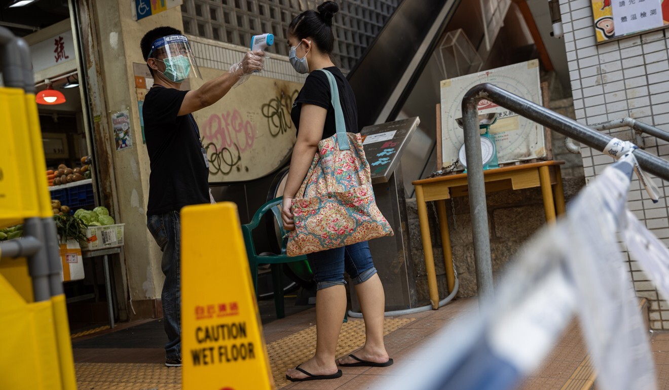A domestic worker has her temperature checked before entering a wet market in Hong Kong. Photo: EPA-EFE