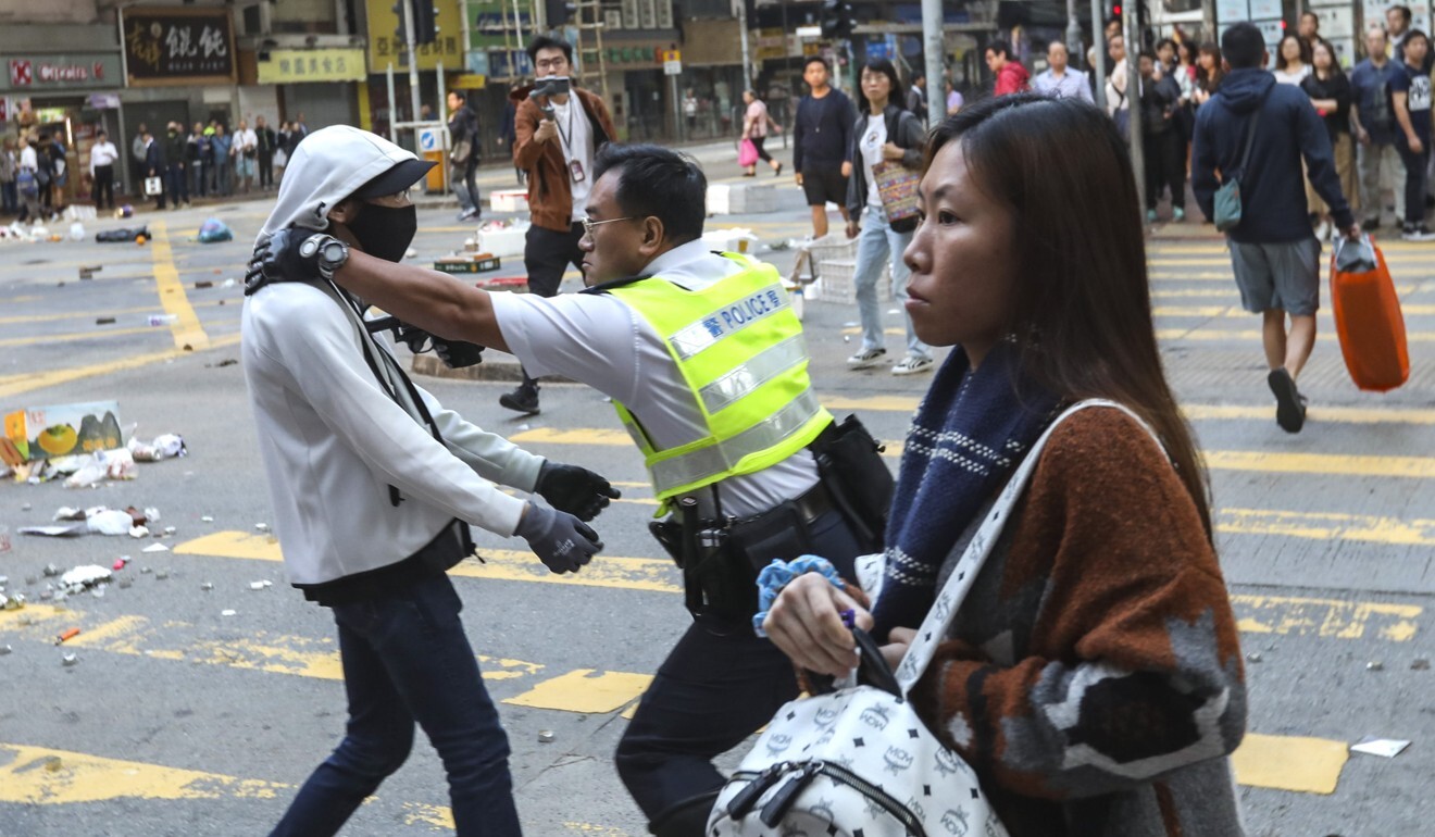 A police officer aims his gun at a protester’s chest in Sai Wan Ho during a confrontation on November 11 last year. Photo: Nora Tam