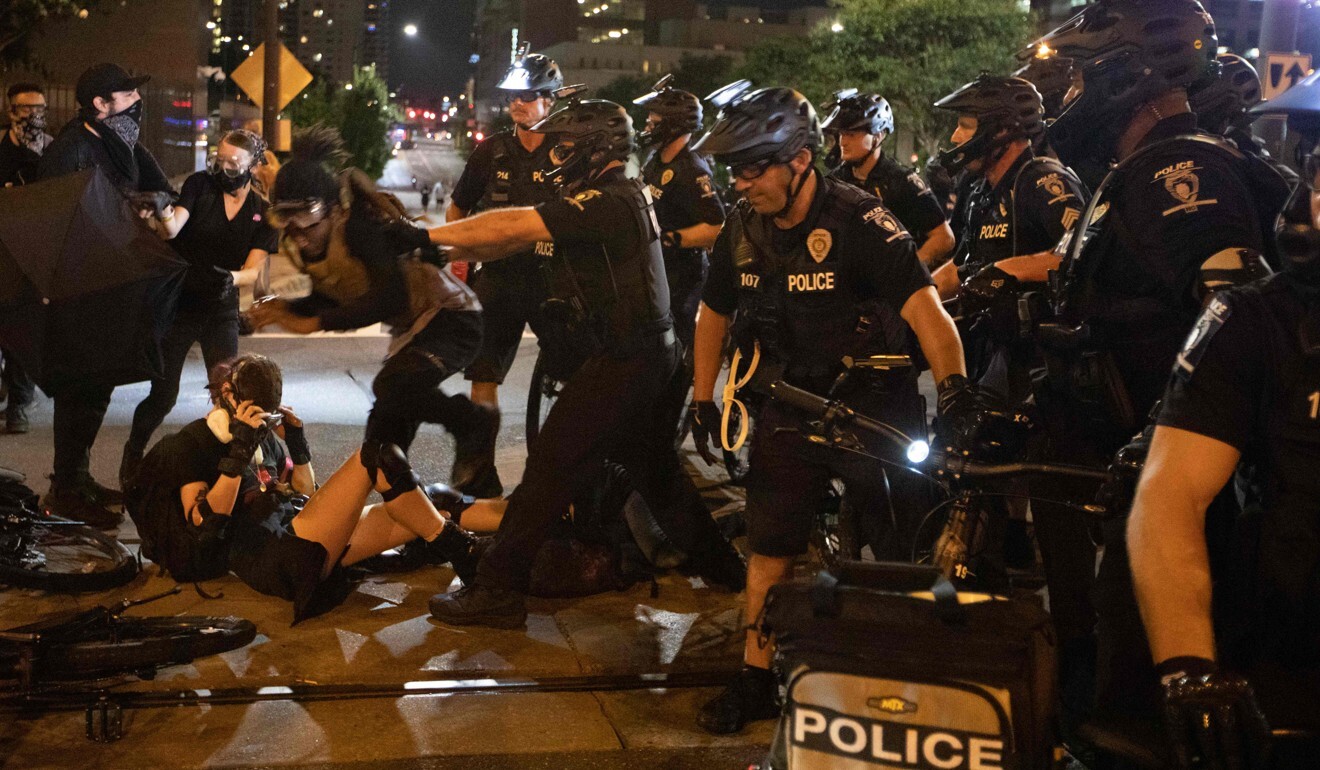 A scuffle ensues as police take a person into custody on Saturday during a protest in Charlotte near the site of the 2020 Republican National Convention. Photo: AFP