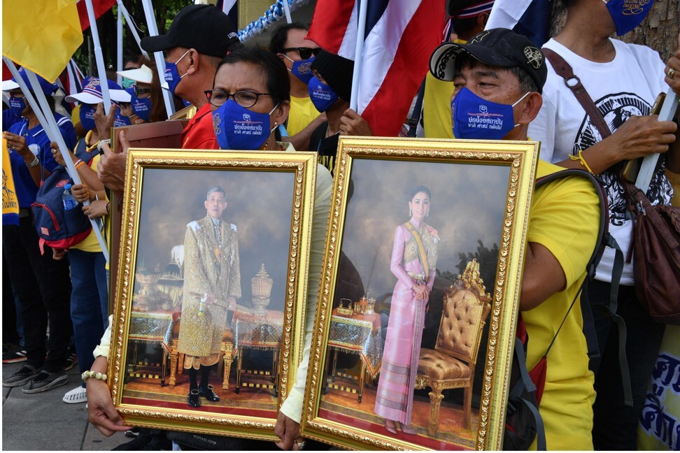 Royalist protesters hold pictures of Thailand’s King Maha Vajiralongkorn and Queen Suthida. Photo: AFP
