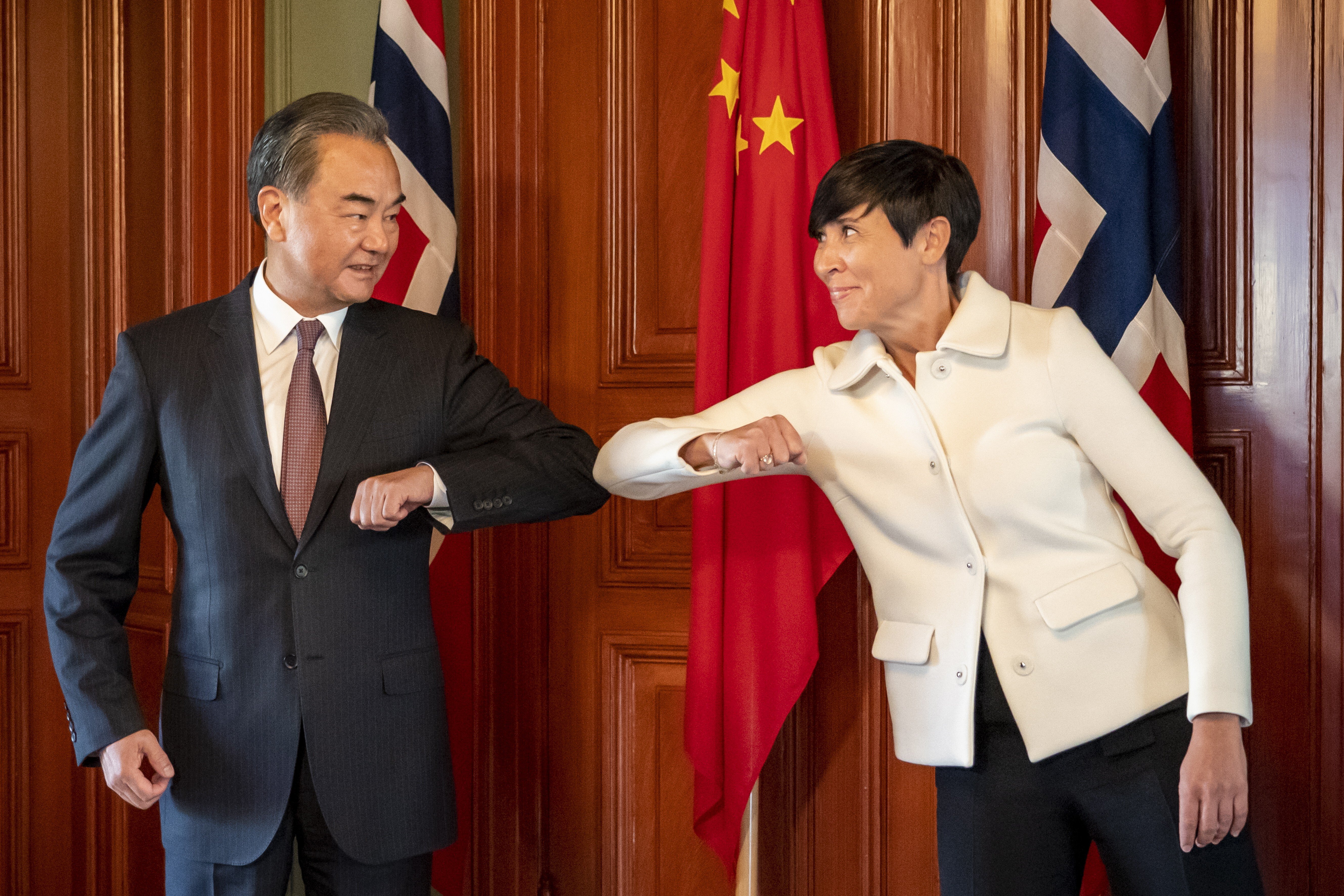 Norway's Foreign Minister Ine Eriksen Soreide (R) makes a corona greeting as she welcomes Chinese Foreign Minister Wang Yi (L) to Norway. Photo: EPA-EFE