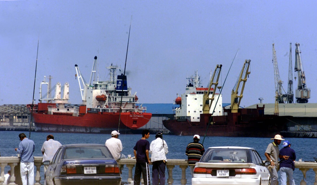 Locals fish on the bank of Tripoli port. Photo: AP