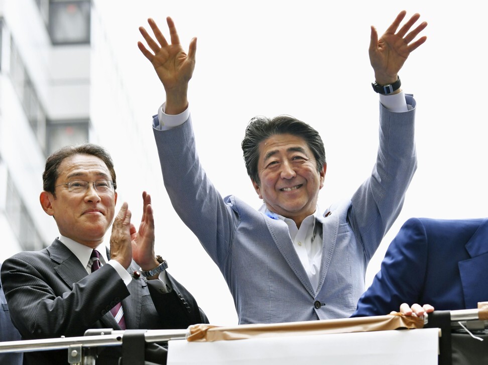 Japanese PM Shinzo Abe waves to supporters, flanked by close aide Fumio Kishida, during a House of Councillors election campaign in July 2019. Photo: Kyodo