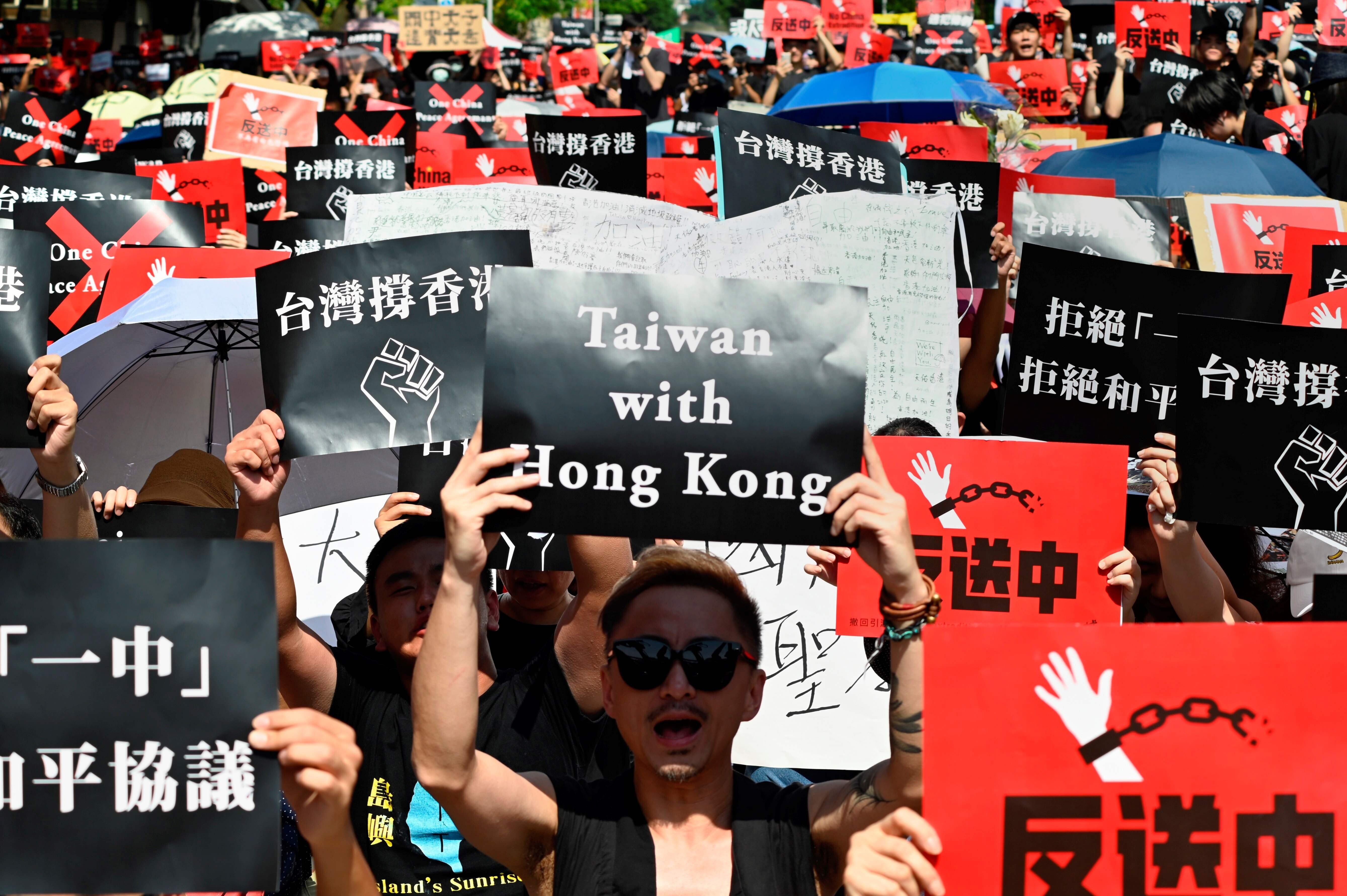 Protesters at a demonstration in Taipei display placards in support of the anti-government protests taking place in Hong Kong. Photo: AFP