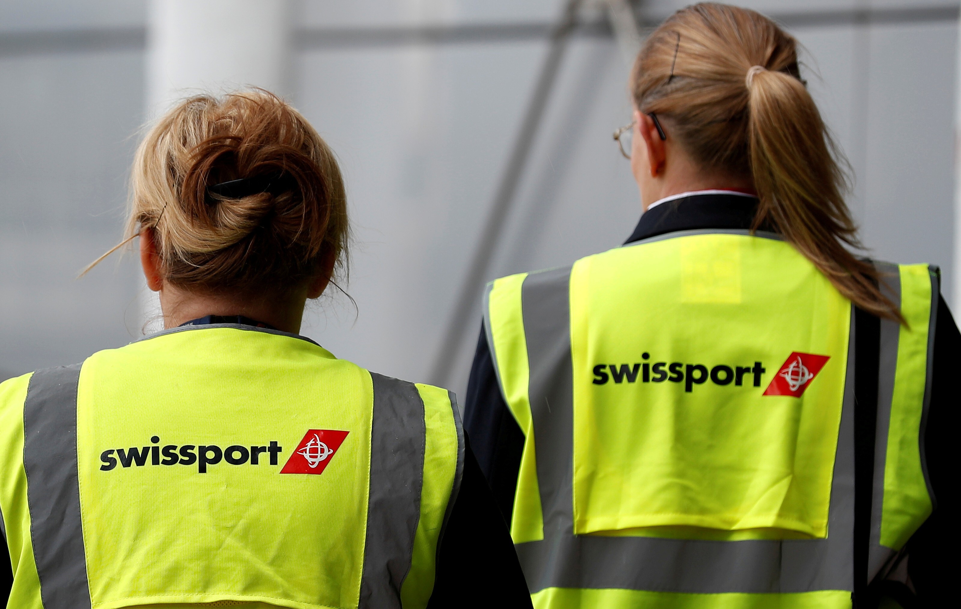 Swissport airport workers walk across the tarmac at Liverpool John Lennon Airport in northern England, in May, 2016. Photo: Reuters