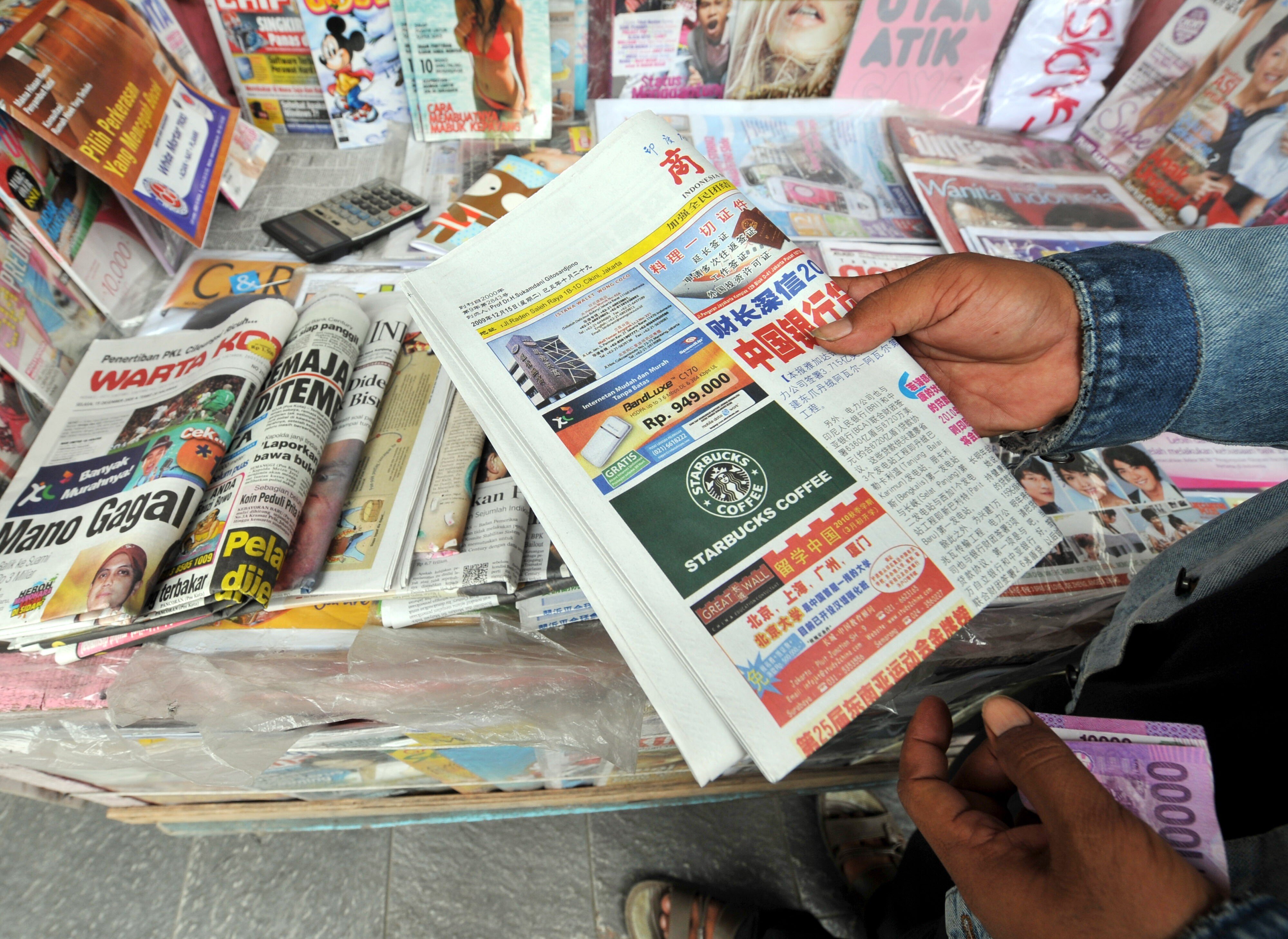 A vendor holds a copy of the ‘Indonesia Shangbao’ newspaper in Jakarta. Photo: AFP