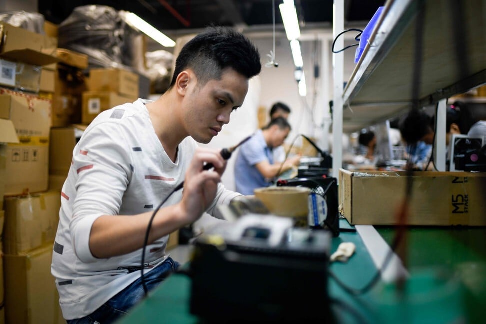 This picture taken on November 9, 2018 shows an employee working at a company producing robots in Shenzhen in southern China's Guangdong province. - The southern city of Shenzhen is the symbol of the transformative reforms launched by China 40 years ago: former fishing villages that morphed into a global manufacturing hub. Today Shenzhen is again at the heart of a new policy aimed at turning China into a hi-tech innovator and shedding its reputation as an assembly line for foreign companies or -- worse -- an imitator. (Photo by WANG Zhao / AFP) / TO GO WITH China-politics-economy-history. FOCUS by Ludovic EHRET