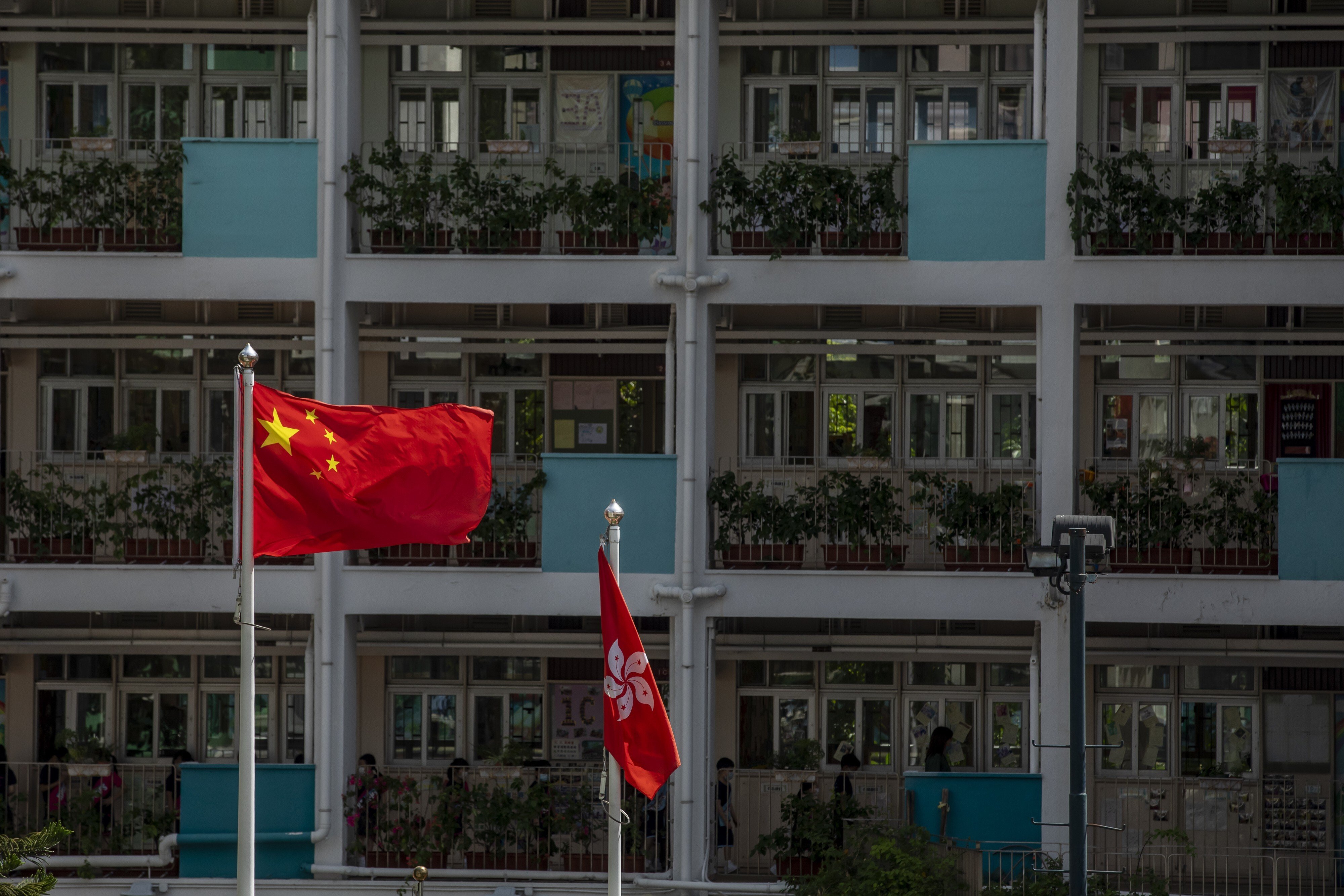 The flags of China and Hong Kong are flown at a school in Hong Kong. Photo: Bloomberg