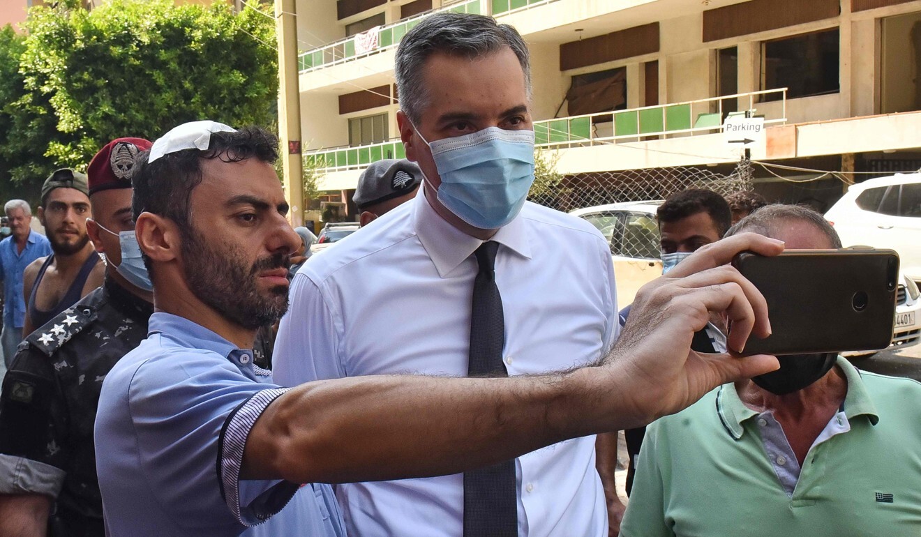 A wounded man takes a picture with the newly-appointed Prime Minister Mustapha Adib during his tour in Beirut's badly-hit Gemmayzeh neighbourhood. Photo: AFP