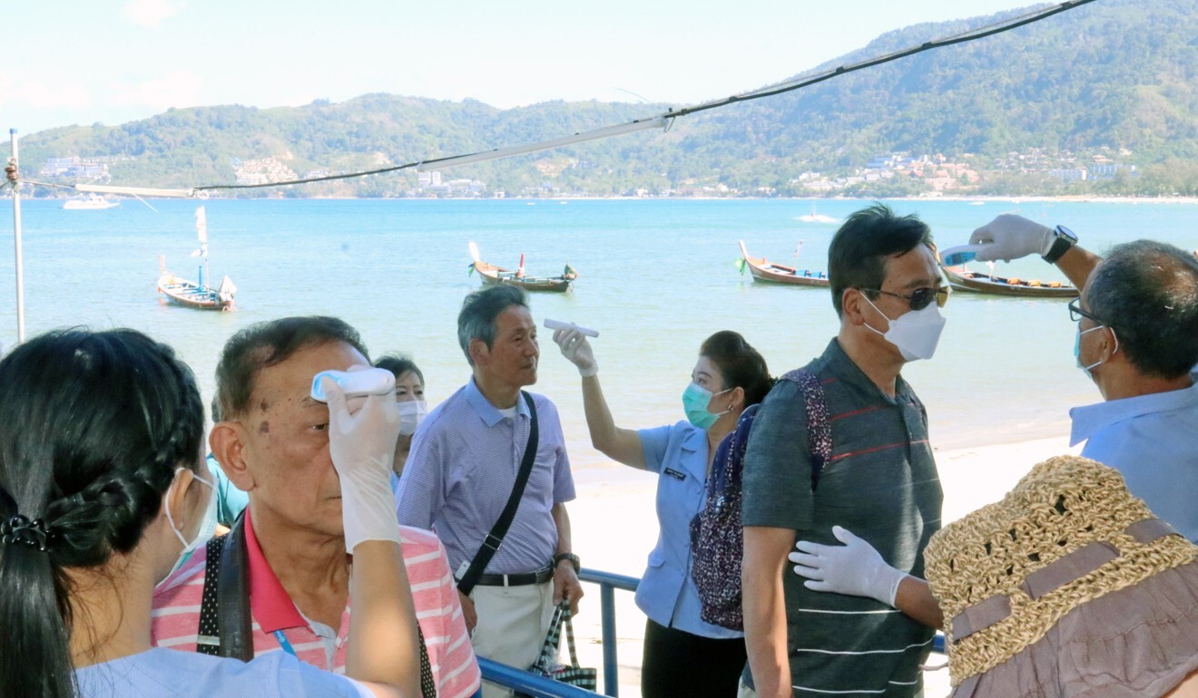 Thai health officials check the temperatures of foreign tourists arriving in Phuket from a cruise ship in February 2020, in the early days of the coronavirus outbreak. Photo: EPA