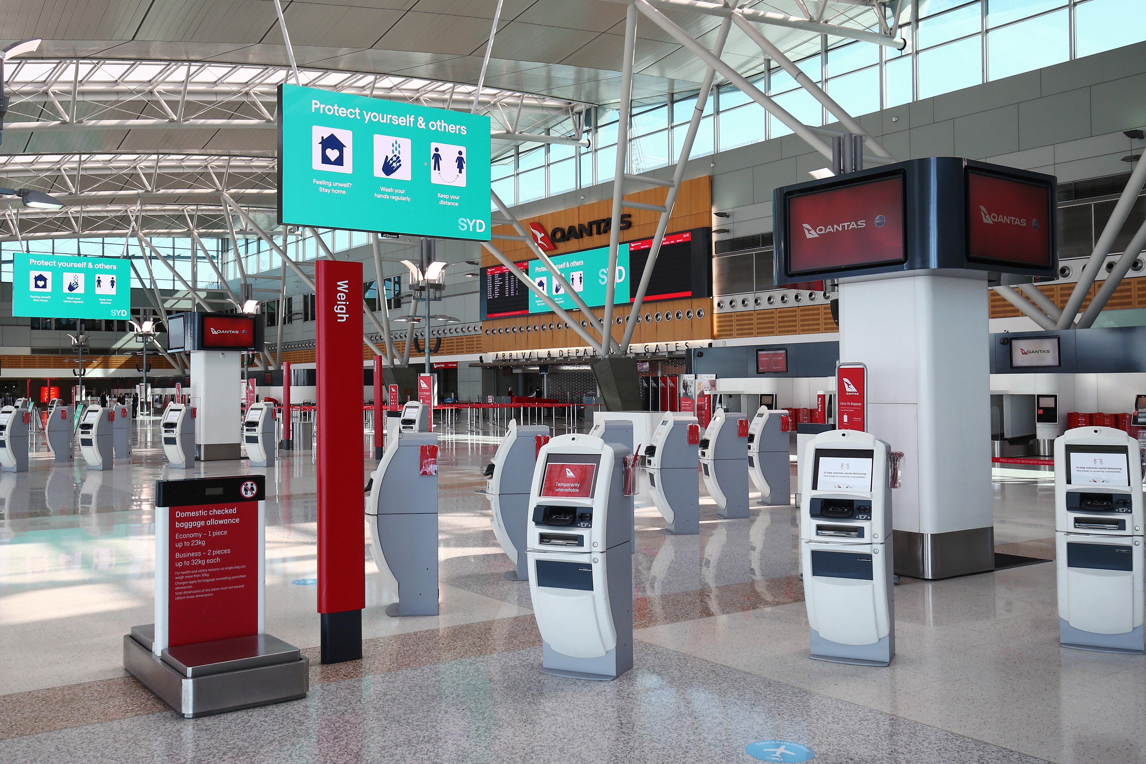 Screens display Covid-19 safety information in the domestic terminal for Qantas Airways at a deserted Sydney Airport on Monday, August 17, 2020. Photo: Bloomberg