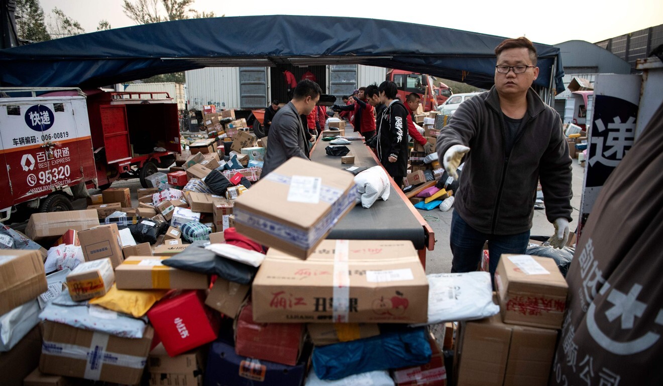 Workers sort out packages at a delivery company warehouse in Beijing. Photo: AFP
