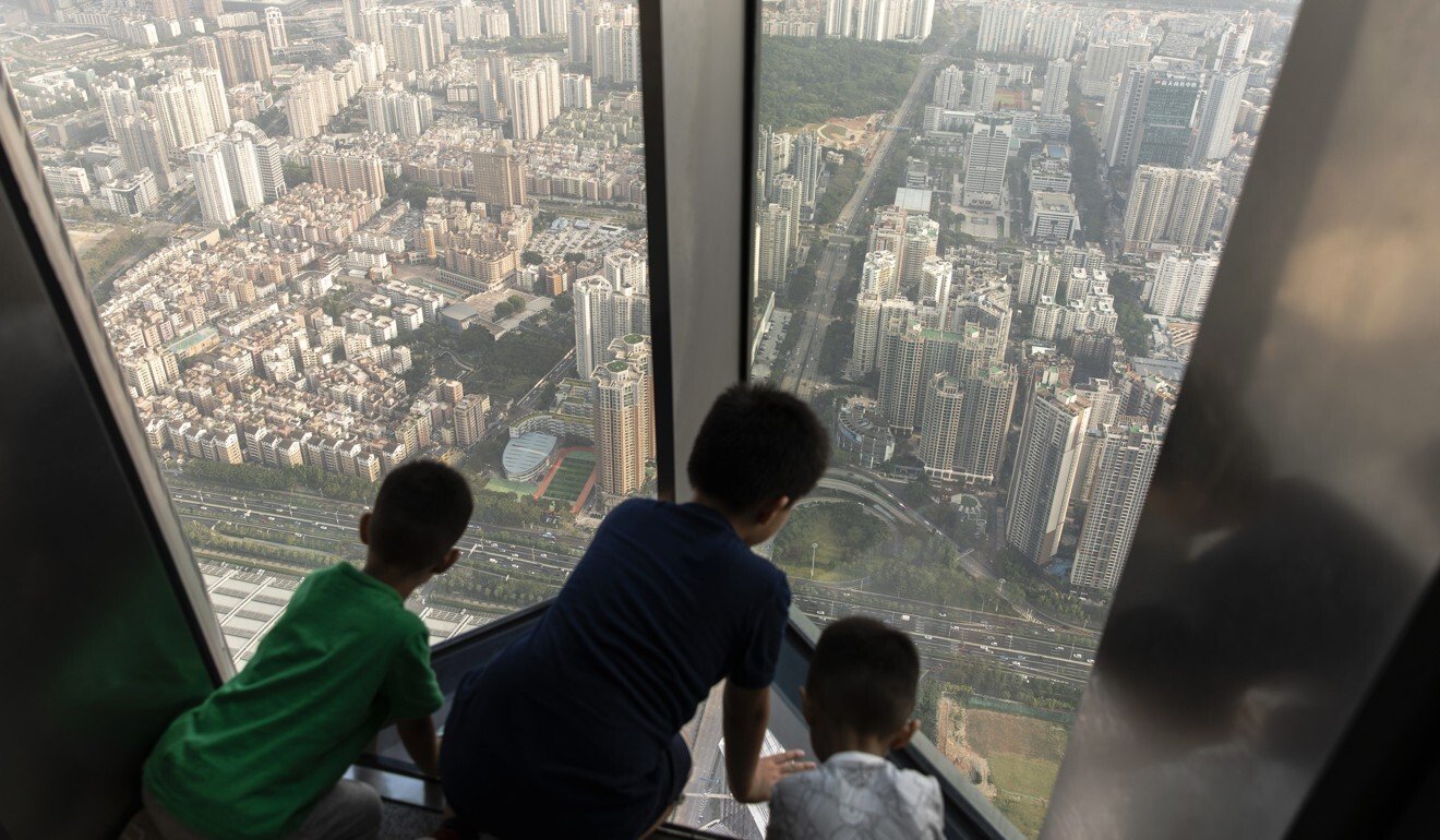 Children look out at buildings from the observation deck of the Ping An Finance Centre in Shenzhen. Photo: Qilai Shen/Bloomberg