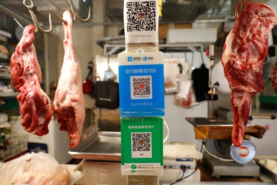 QR codes of the digital payment services WeChat Pay and Alipay seen at a meat stall at a fresh market in Beijing on August 8. Photo: Reuters