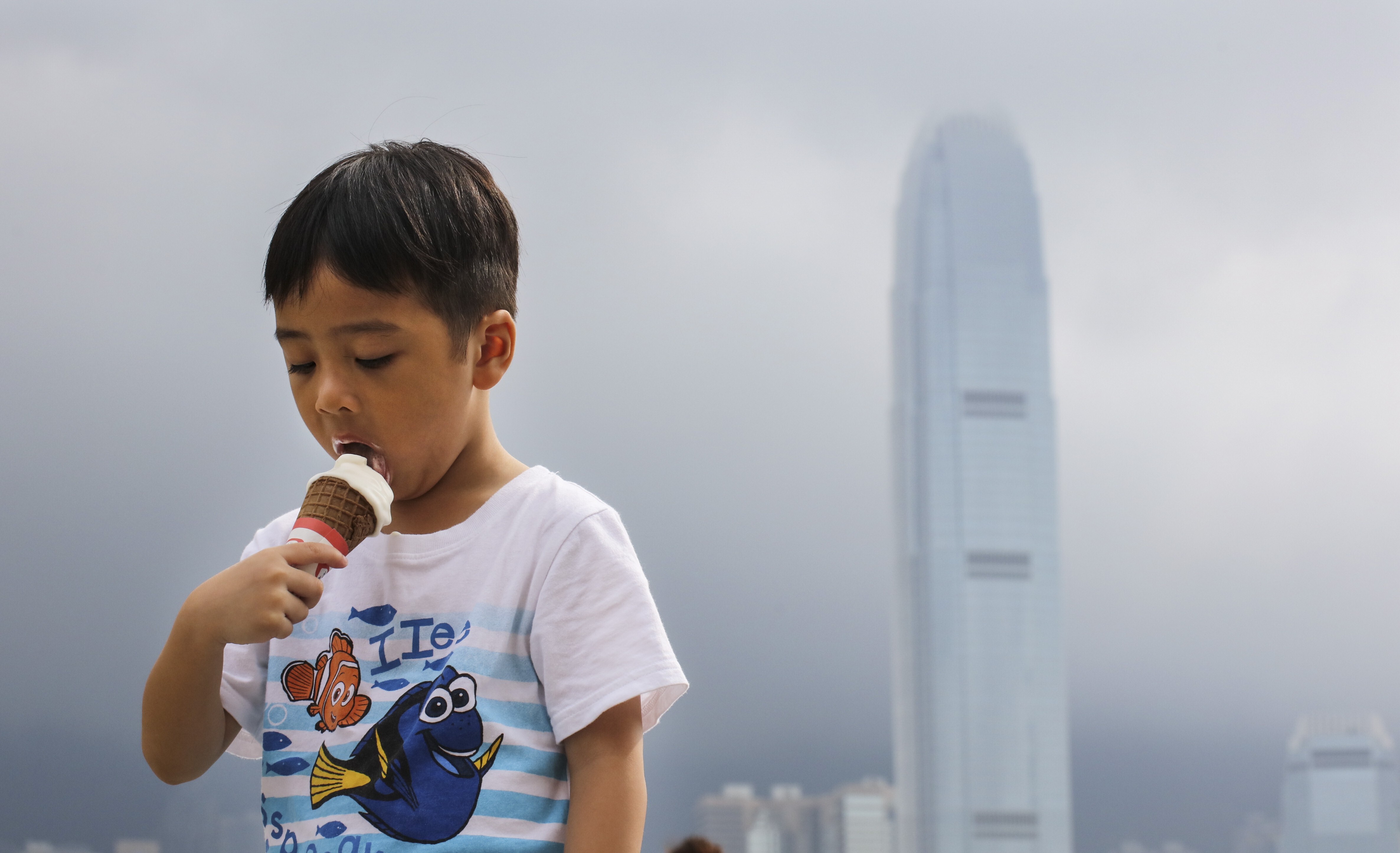 A boy eats ice cream near Victoria Harbour in Hong Kong on July 31, 2017, when the Observatory issued a “very hot” weather warning. This year, Hong Kong experienced its hottest July since records began. Photo: Felix Wong