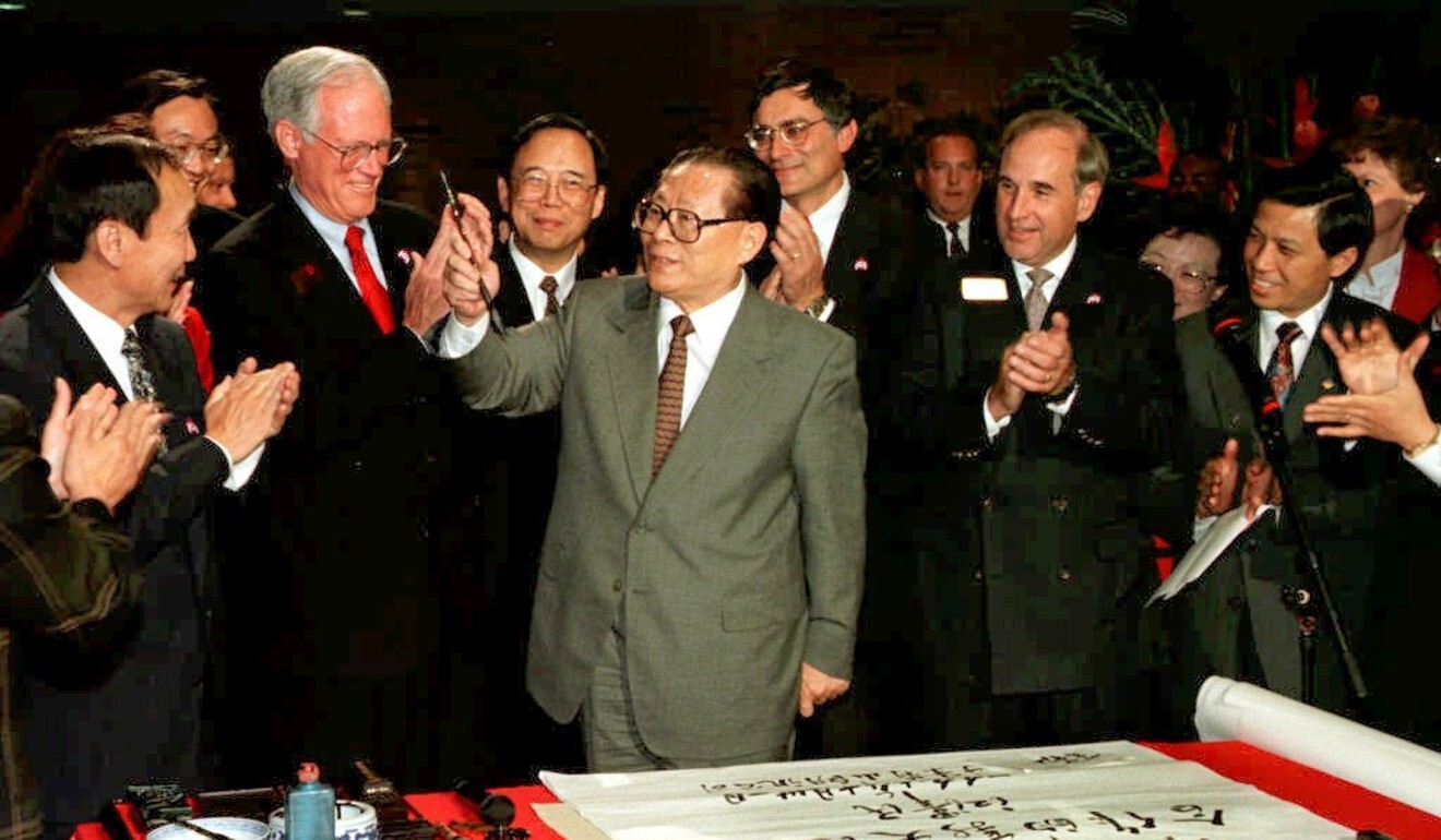 Then Chinese president Jiang Zemin holds a calligraphy brush, as he is applauded by executives of Lucent Technologies after he finished painting a message in Chinese calligraphy at the end of his 1997 tour of Bell Labs in Murray Hill, New Jersey. The message was: “To start a new horizon in high technology cooperation”, signed with his name. Photo: AFP