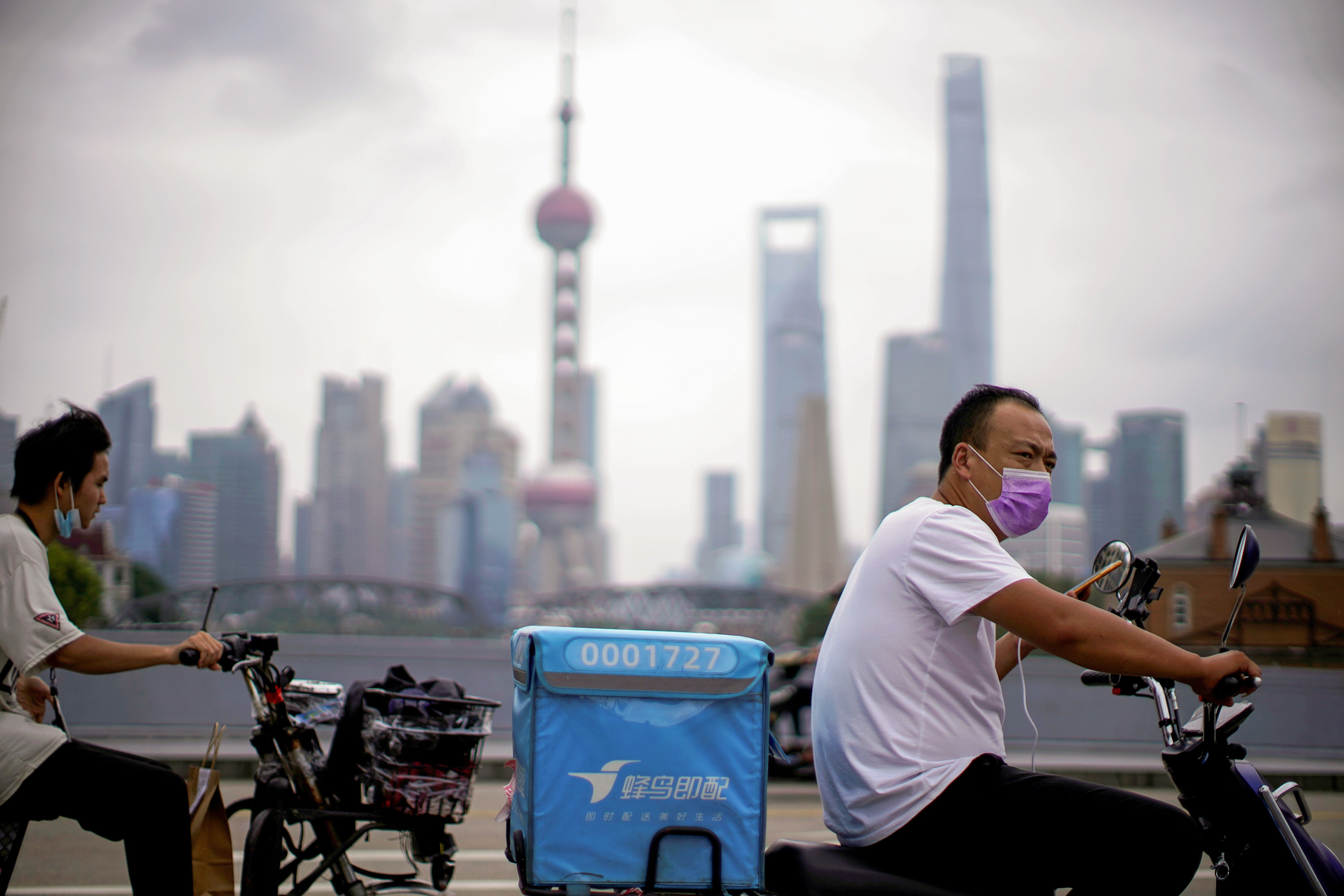 Delivery workers ride through Shanghai. During Covid-19 lockdowns, apps allowed people to buy food and other necessities without leaving their homes. Photo: Reuters