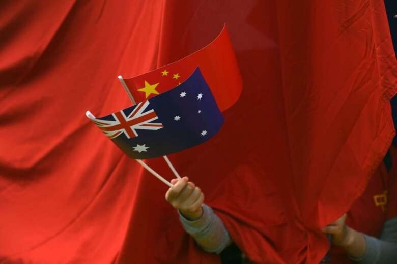 A man waves Chinese and Australian national flags outside Parliament House in Canberra, Australia, in 2017. Photo: EPA